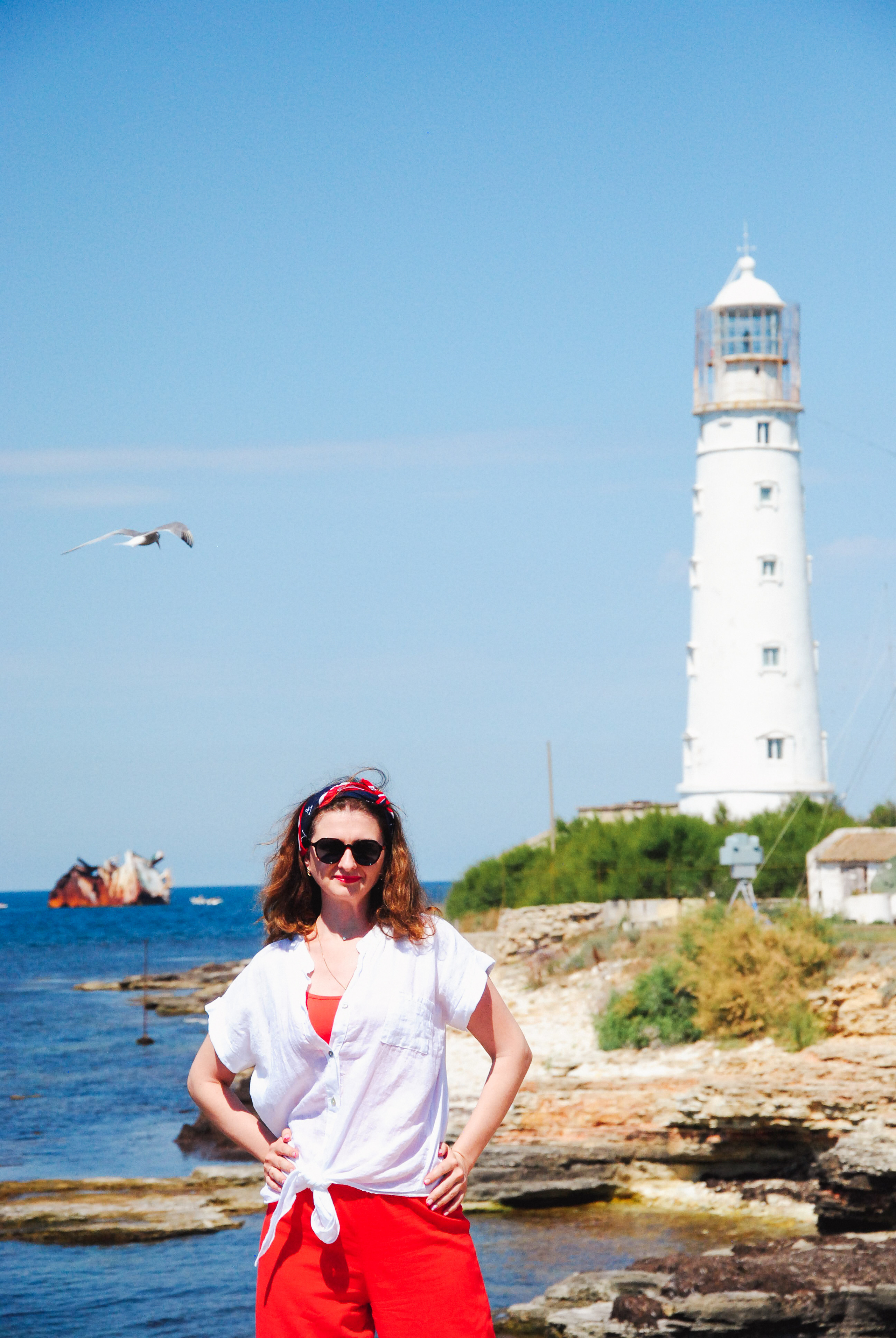 Модель в морятском стиле позирует на фоне синего моря, голубого неба и затопленного сухогруза, вблизи мыса Тарханкут .