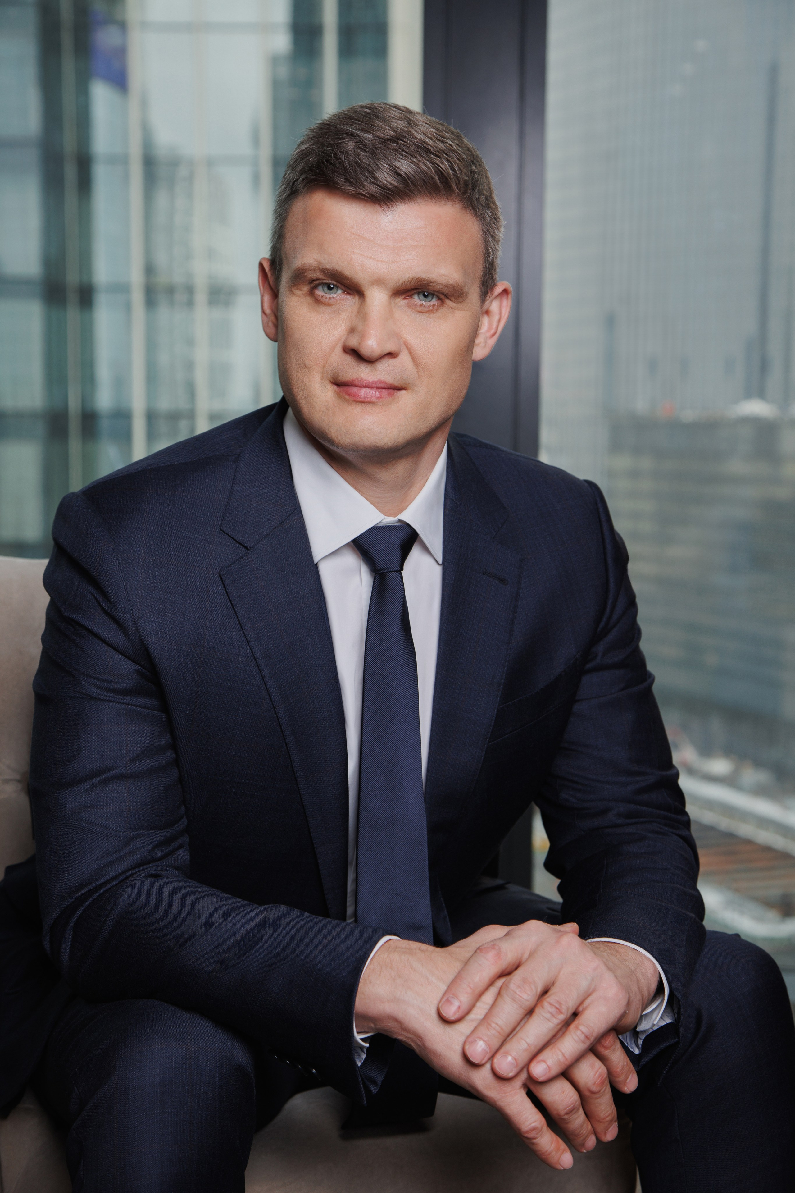 Мужчина работает за ноутбуком в офисе с видом на небоскребы Москва-Сити.