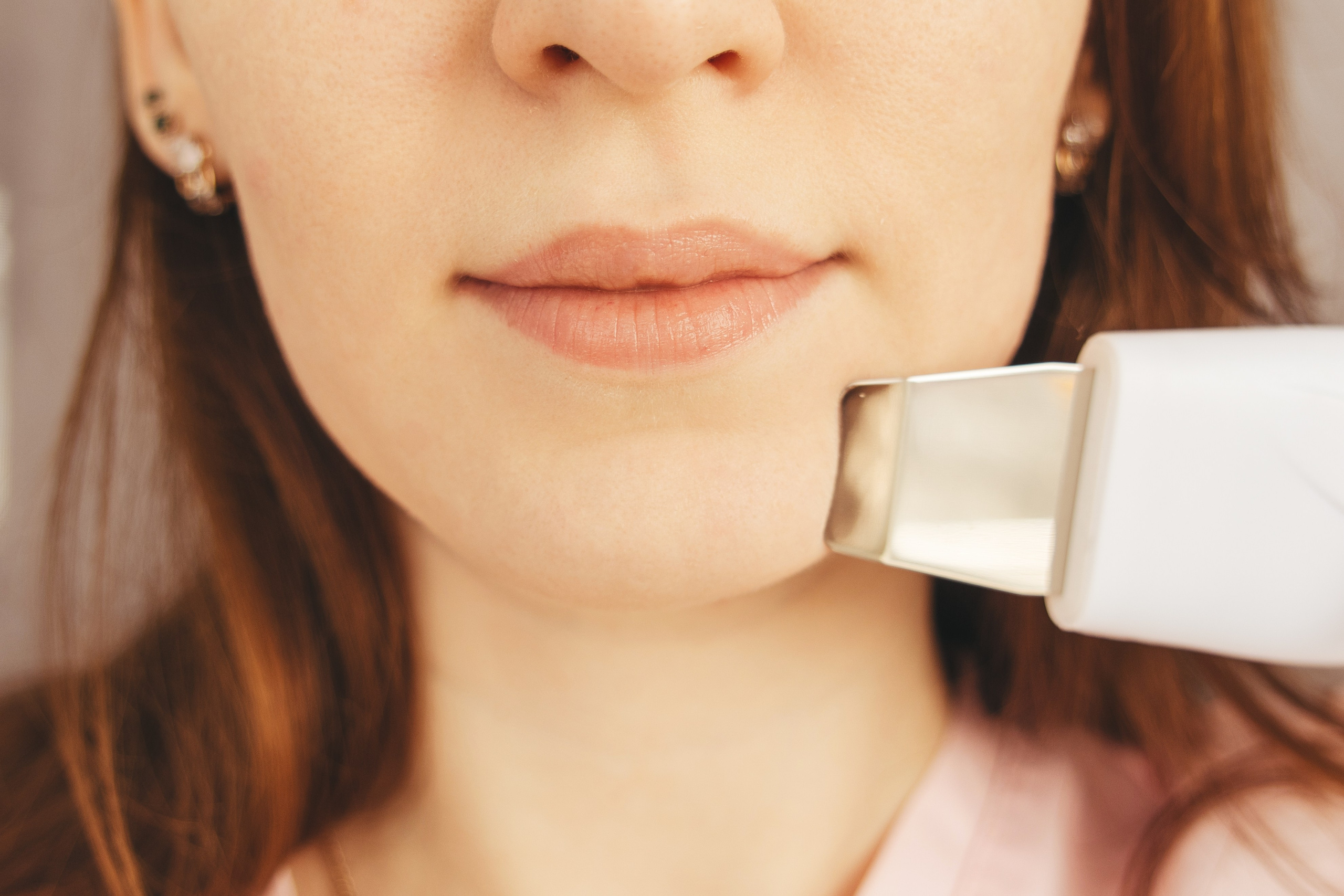 Косметолог и его аппарат на лице, крупный план