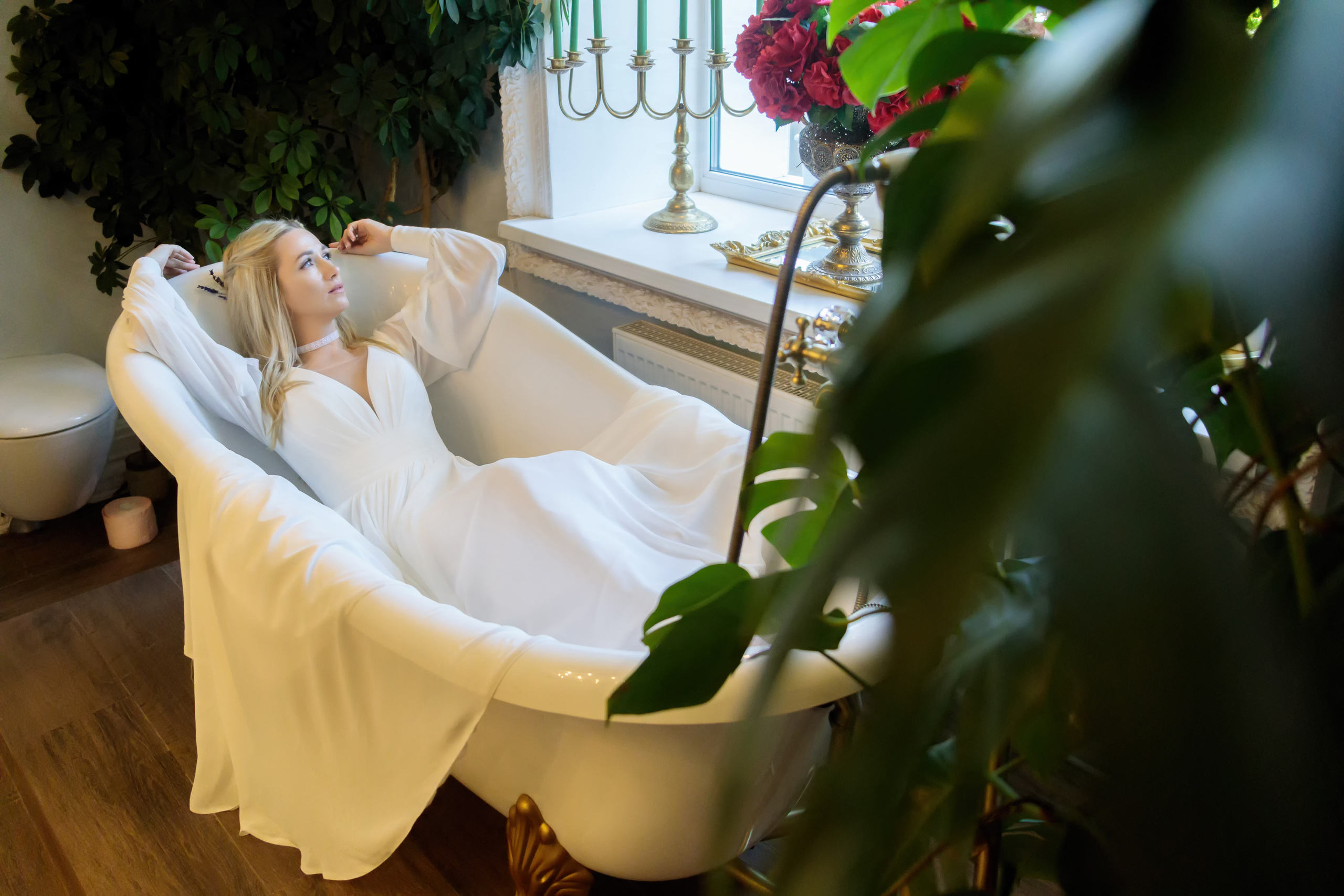 невеста в белом платье лежит в ванне на фоне лета
