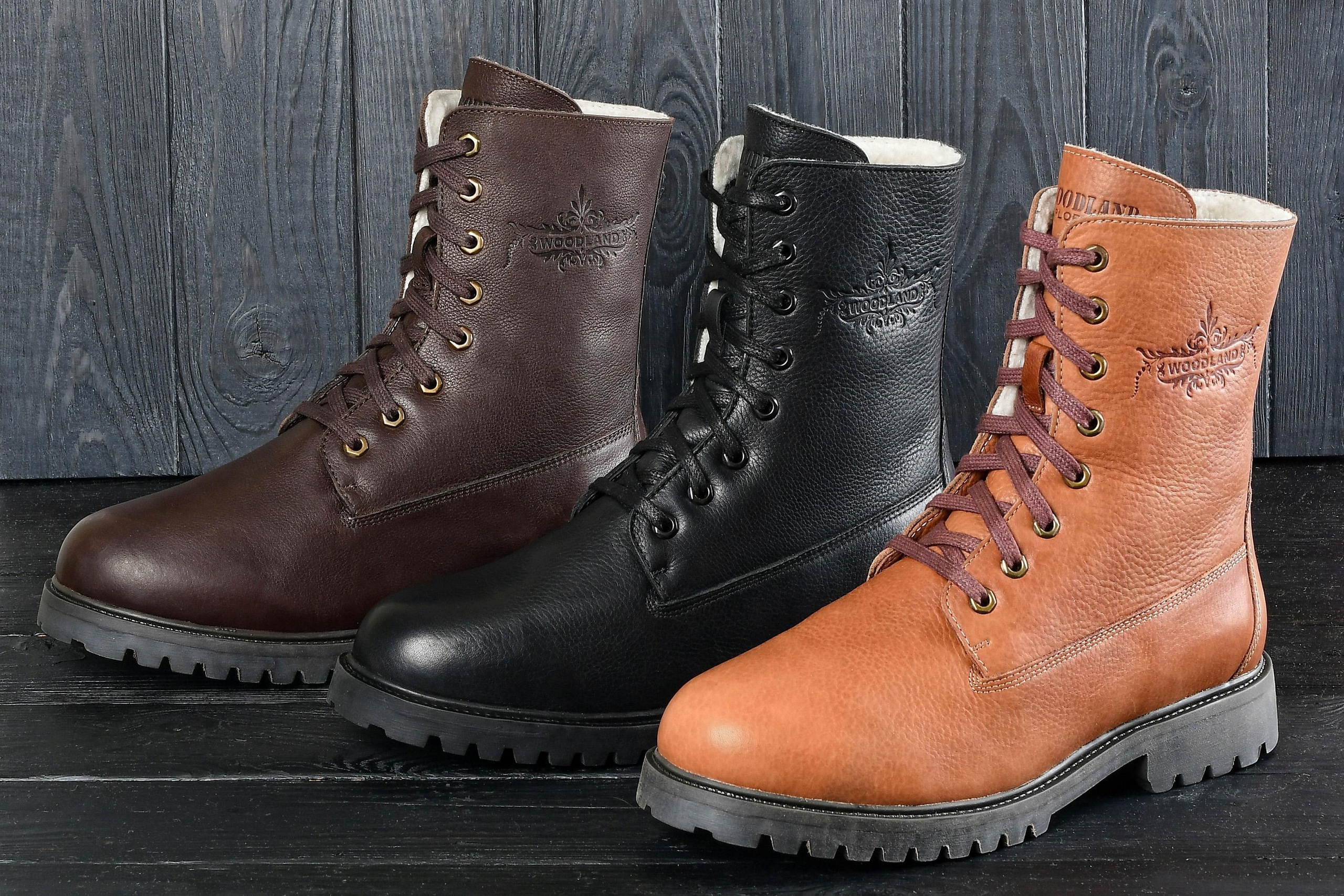 коричневый, черный и бежевый ботинки на фоне дерева