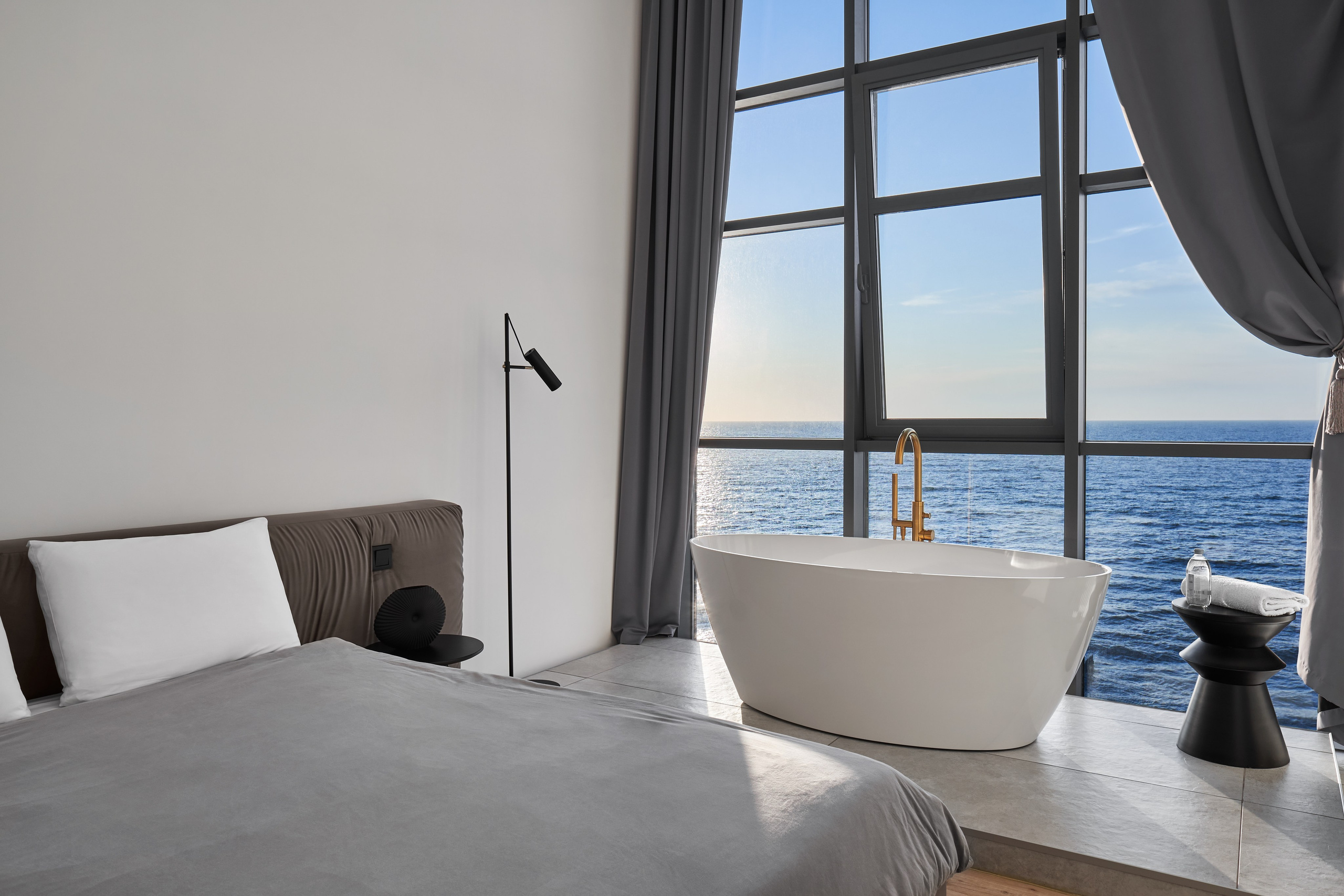 Подиум с ванной в спальне, в квартире с видом на море