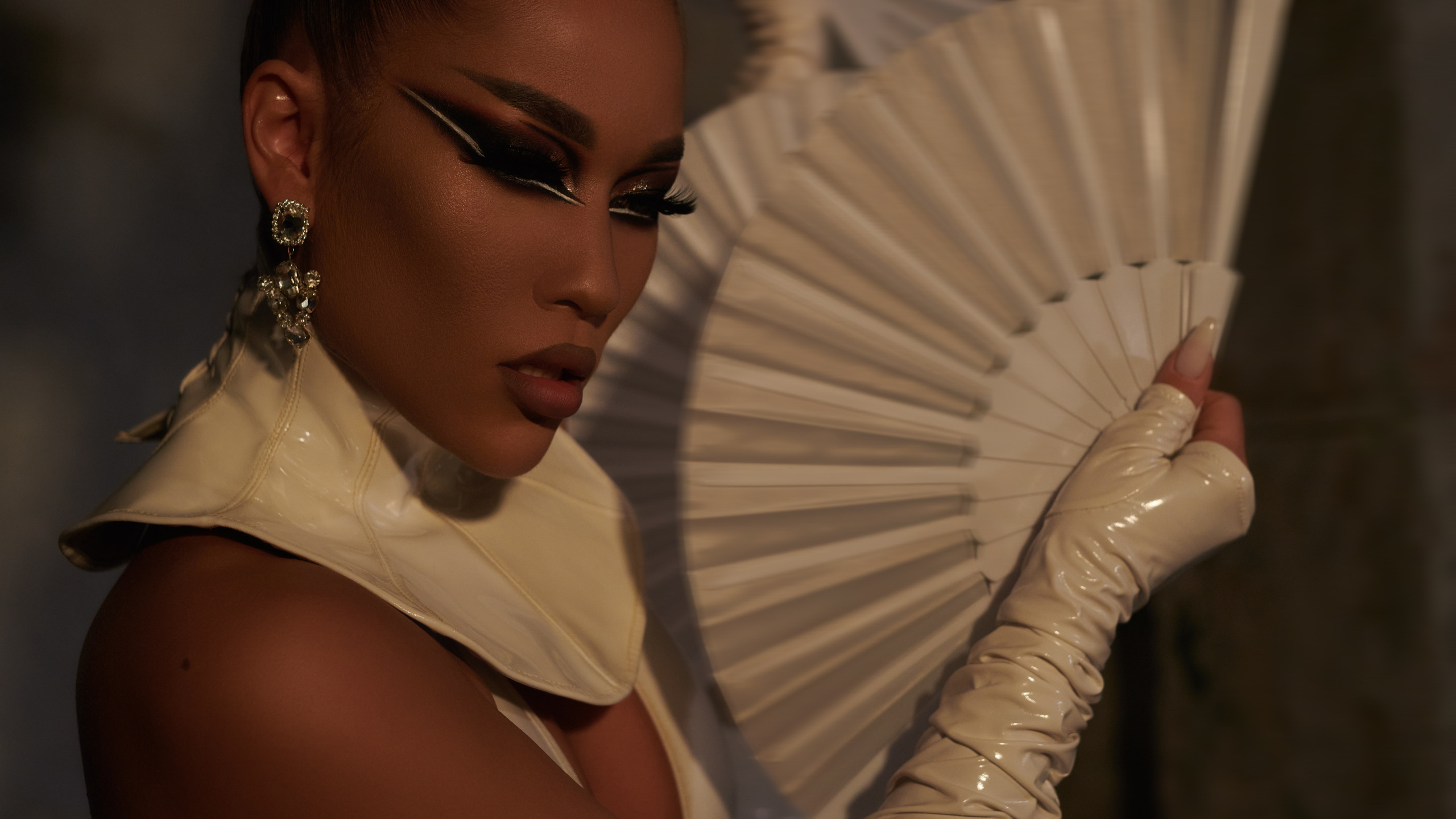 Sexy Asian woman in a latex suit with a fan