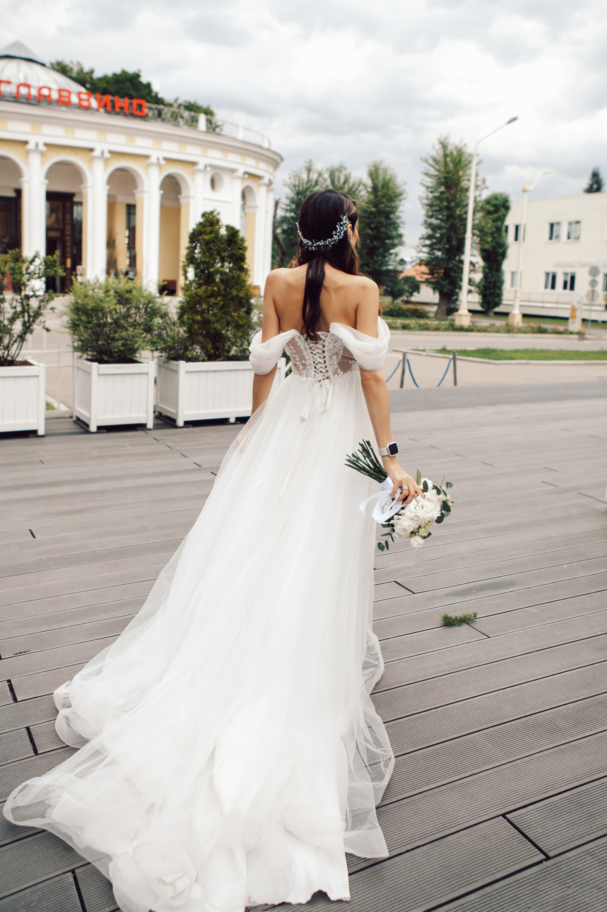 Современное платье с длинным шлейфом у невесты, которая идет на свидание к жениху