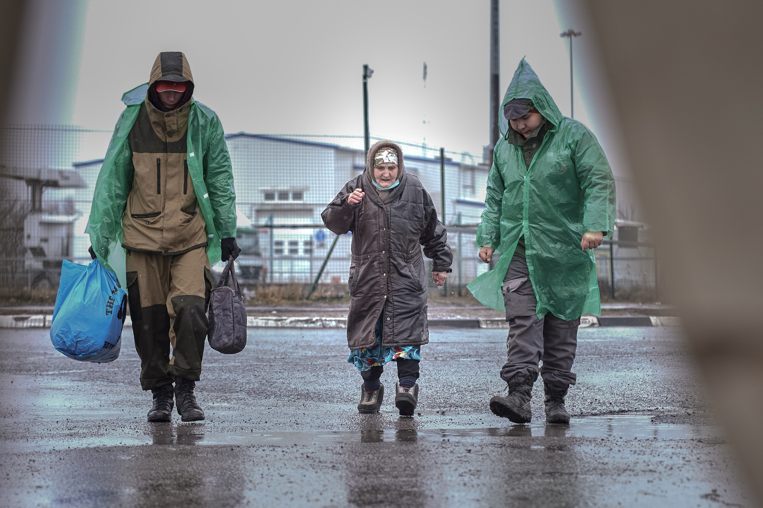 Volunteers assist an elderly woman into a warming tent after crossing a border checkpoint at the Russia-Donetsk border in Avilo-Uspenka village, Rostov region, on the day of Russia's full-scale invasion of Ukraine, February 24, 2022.