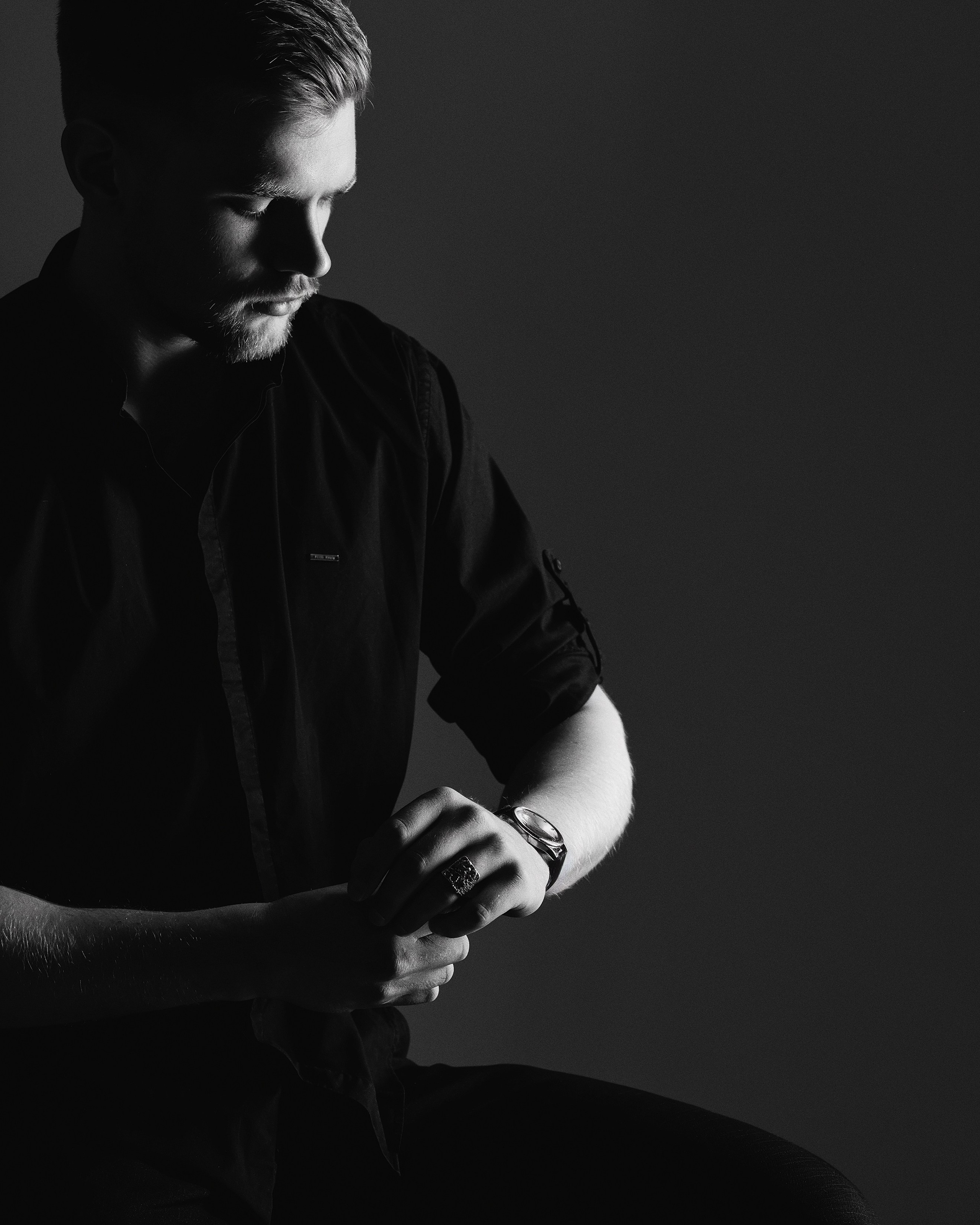 Мужчина смотрит на наручные часы, студийная съемка в низком ключе, фотограф в Пензе Александра Овечкина.