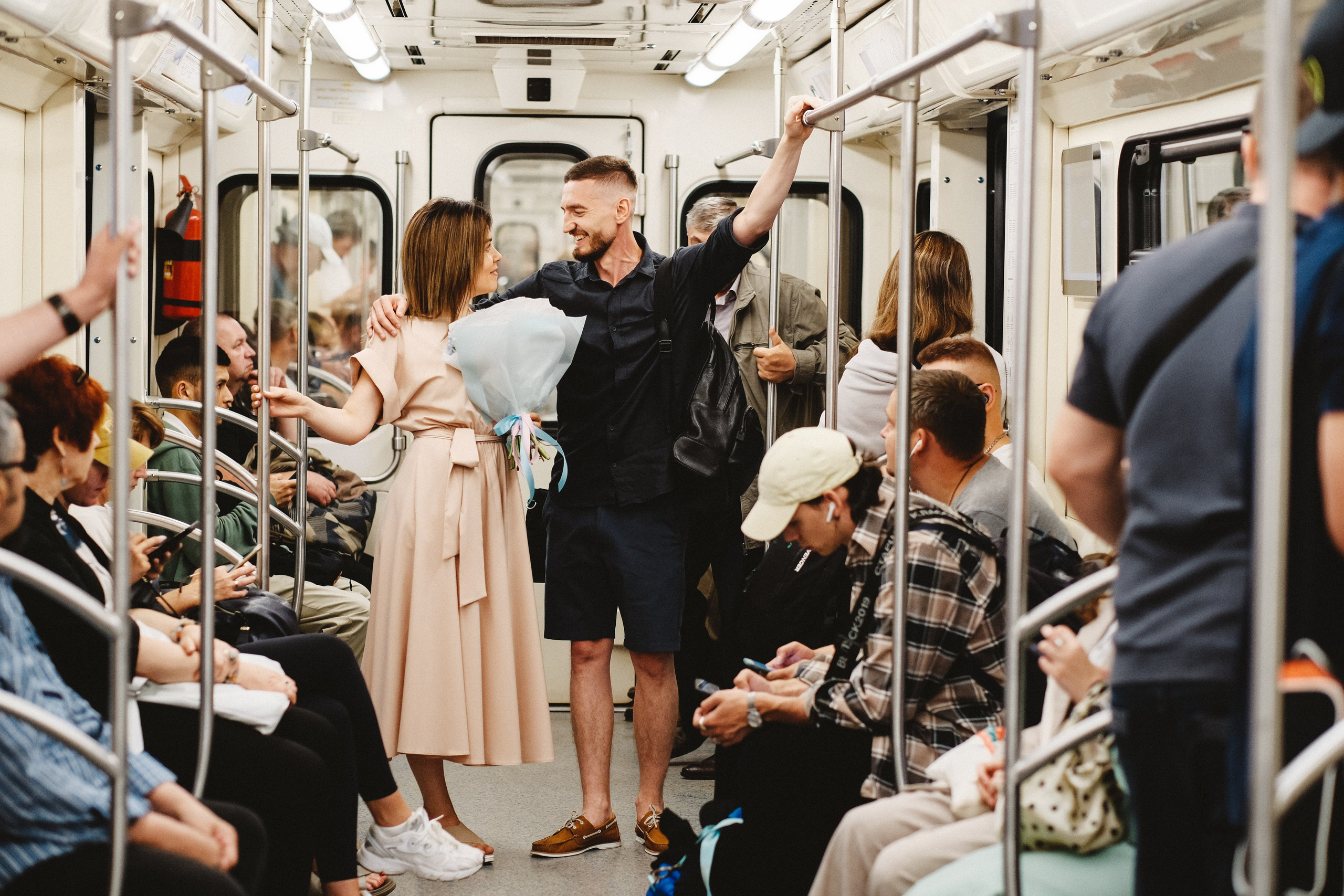 Молодожены едут в метро. Вокруг сидят озабоченные люди.