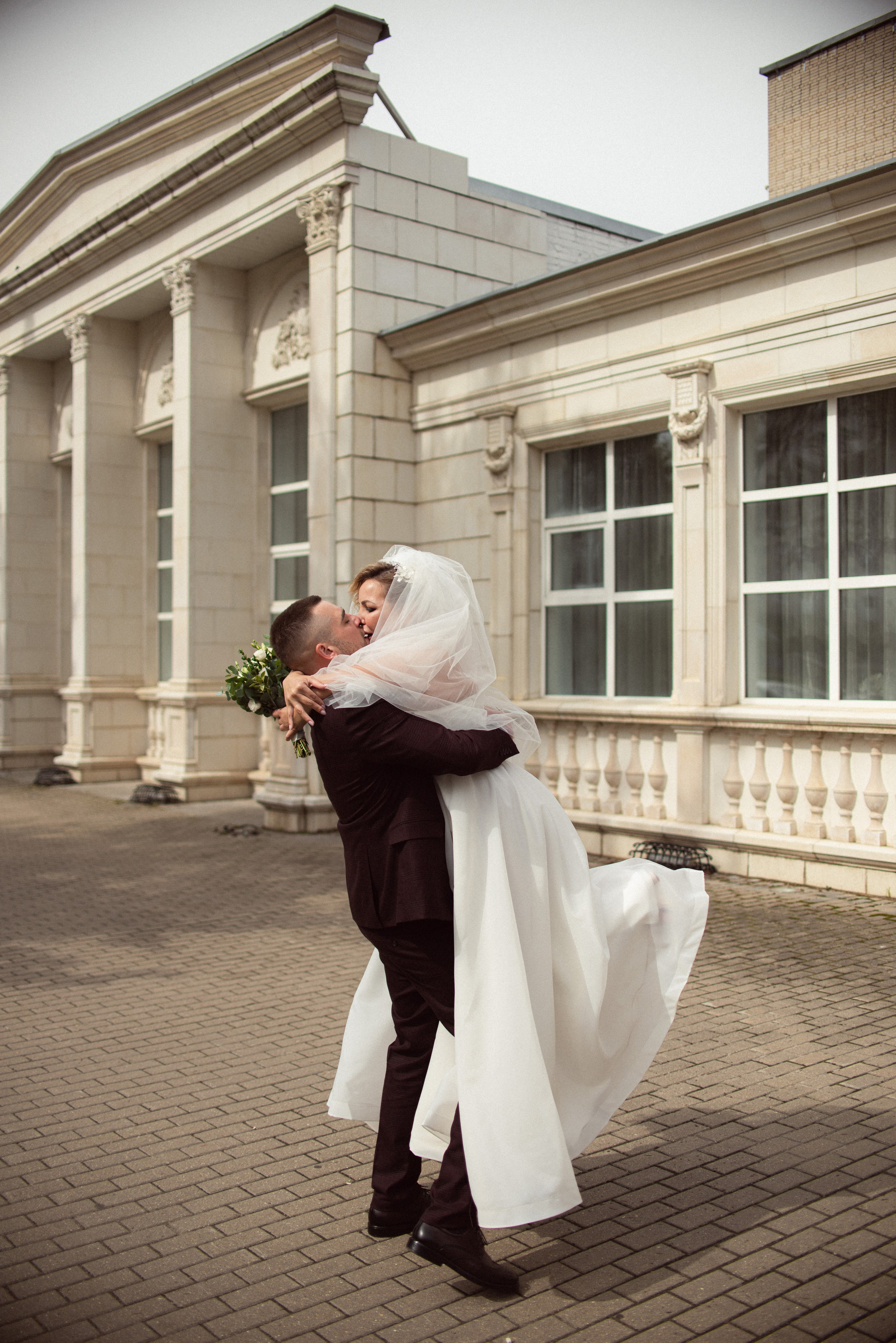 Счастливые молодожены на улице в Старой Купавне: жених подхватывает невесту на руки, фотограф Макеева Алёна