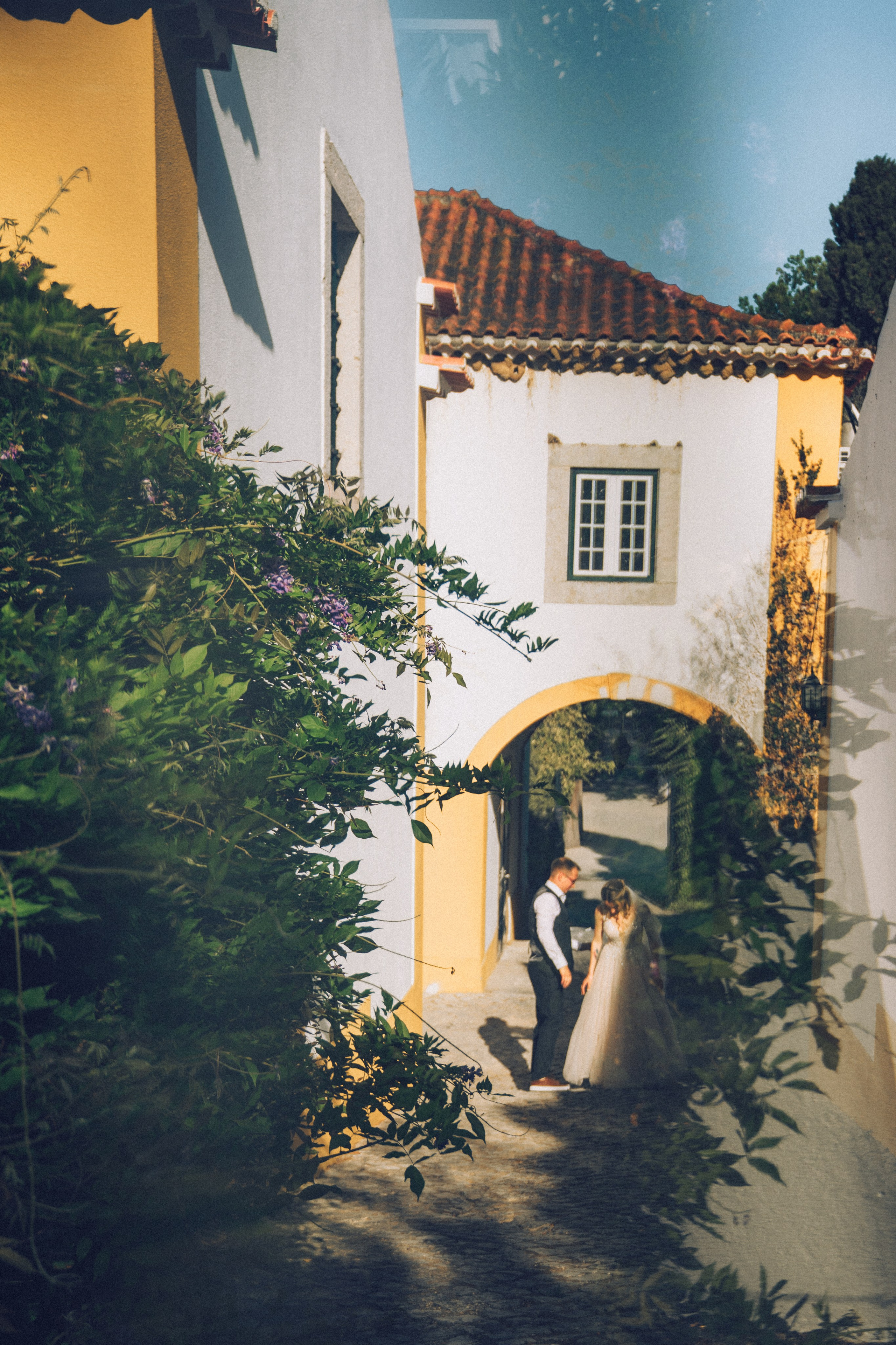 Влюбленная  пара жених и невеста целуется и обнимаются на фоне старинных улочек Португалии