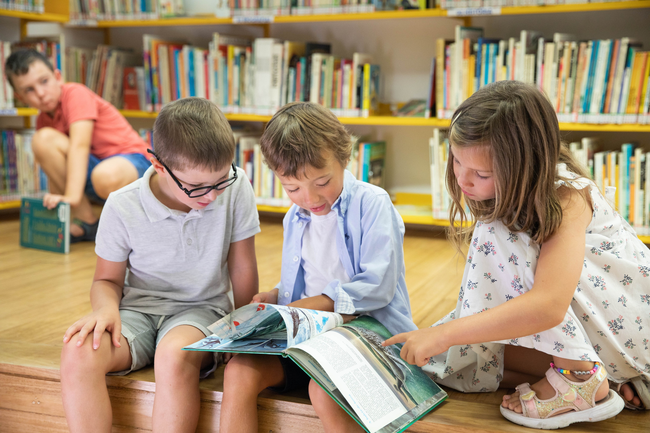 Children sitting on the floor, eagerly flipping through picture books. Boys and girls gathered around a big book, eagerly following the tale