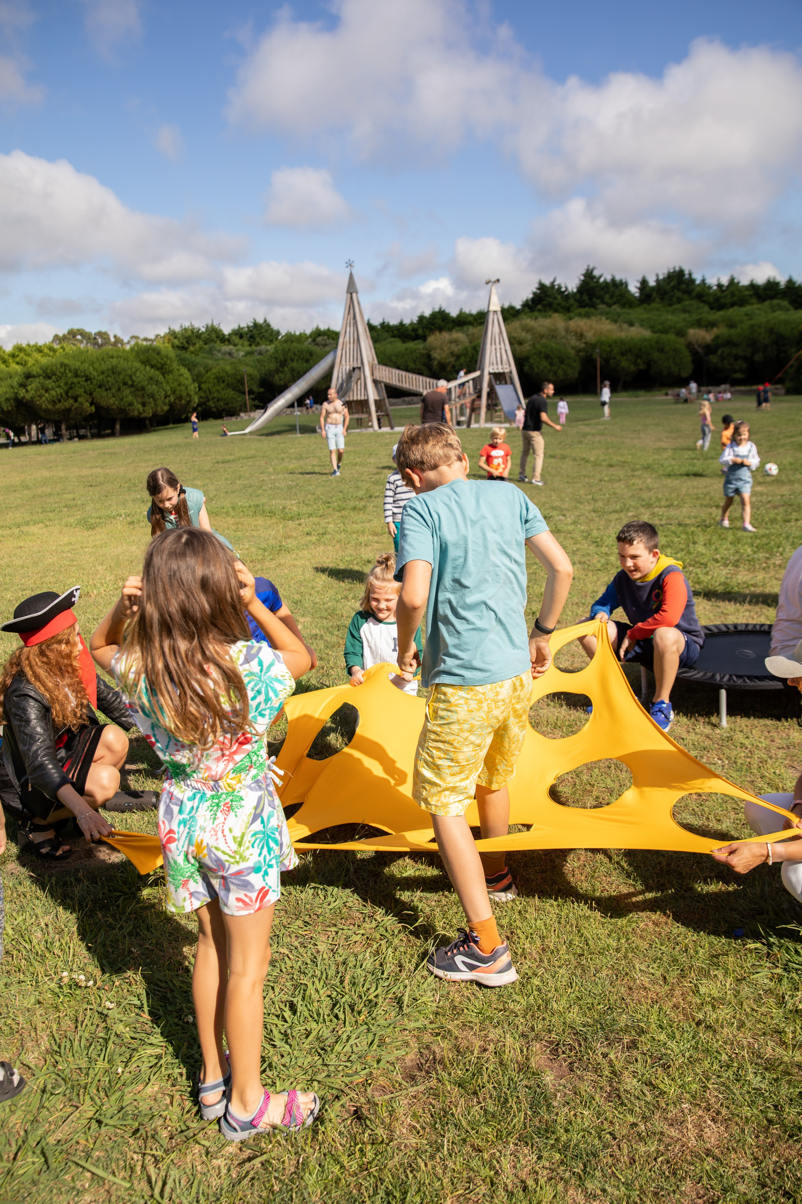 Children playing games and chasing soap bubbles at a birthday photo shoot in the park