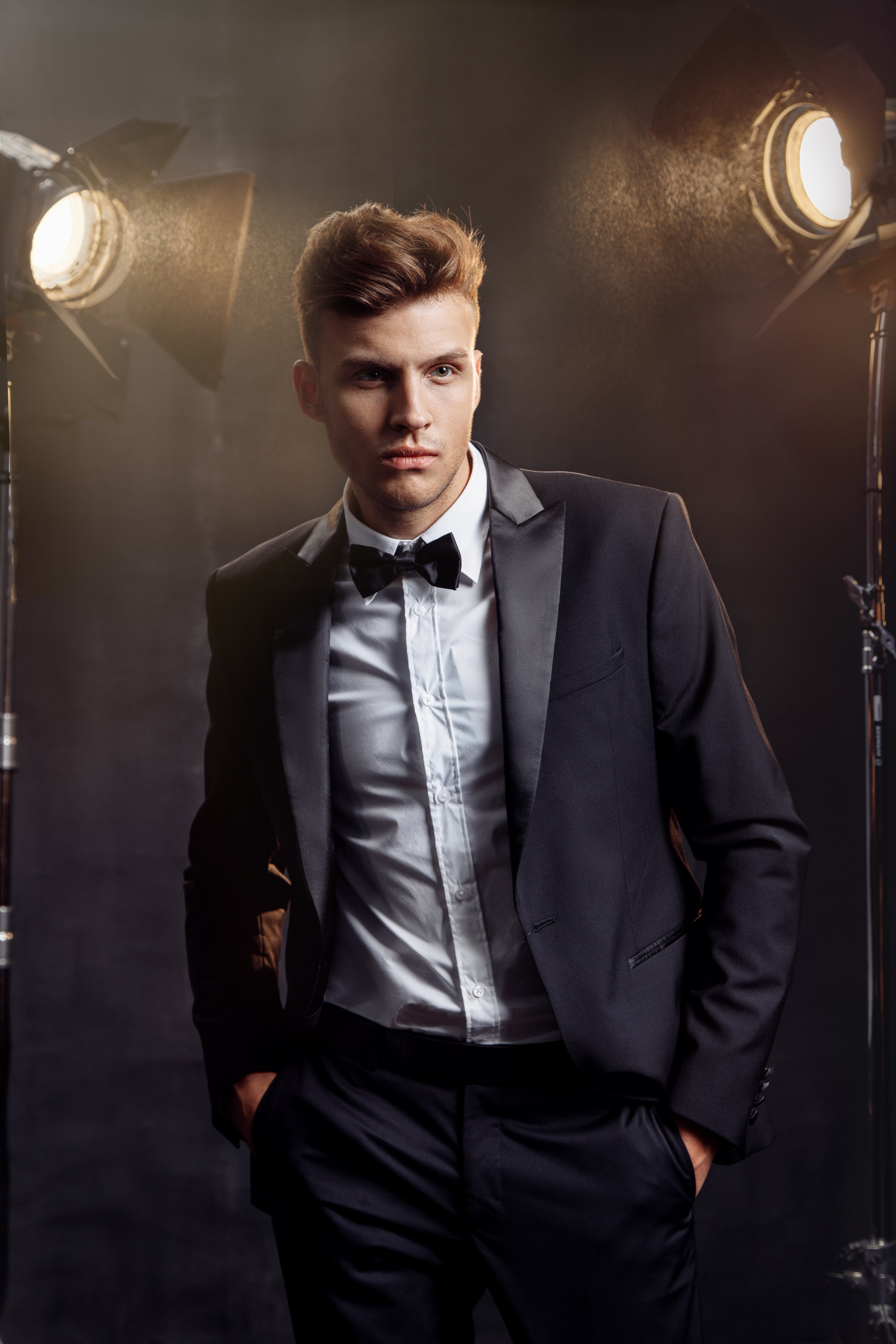 Мужчина в смокинге на темном фоне, силуэт подсвечен контровым светом.