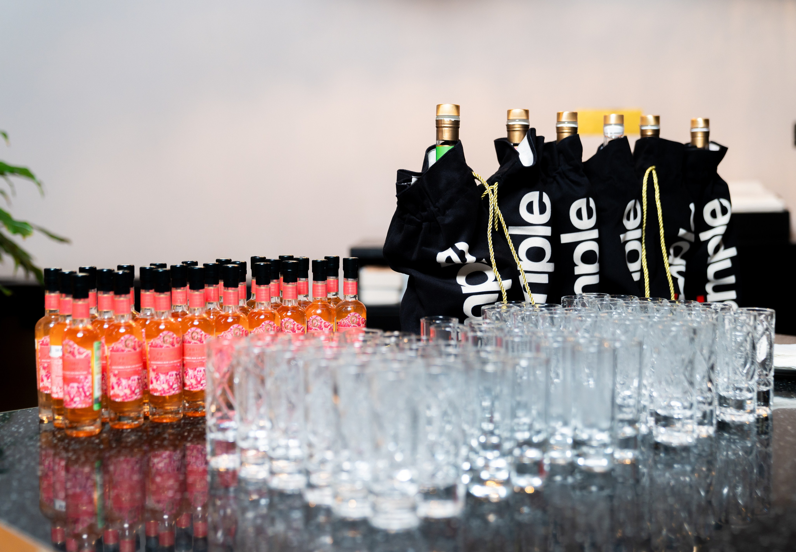 Бутылки с напитком и чёрные подарочные мешочки apple на барной стойке. Фото Евгения Мальцева, Radisson Sonya.