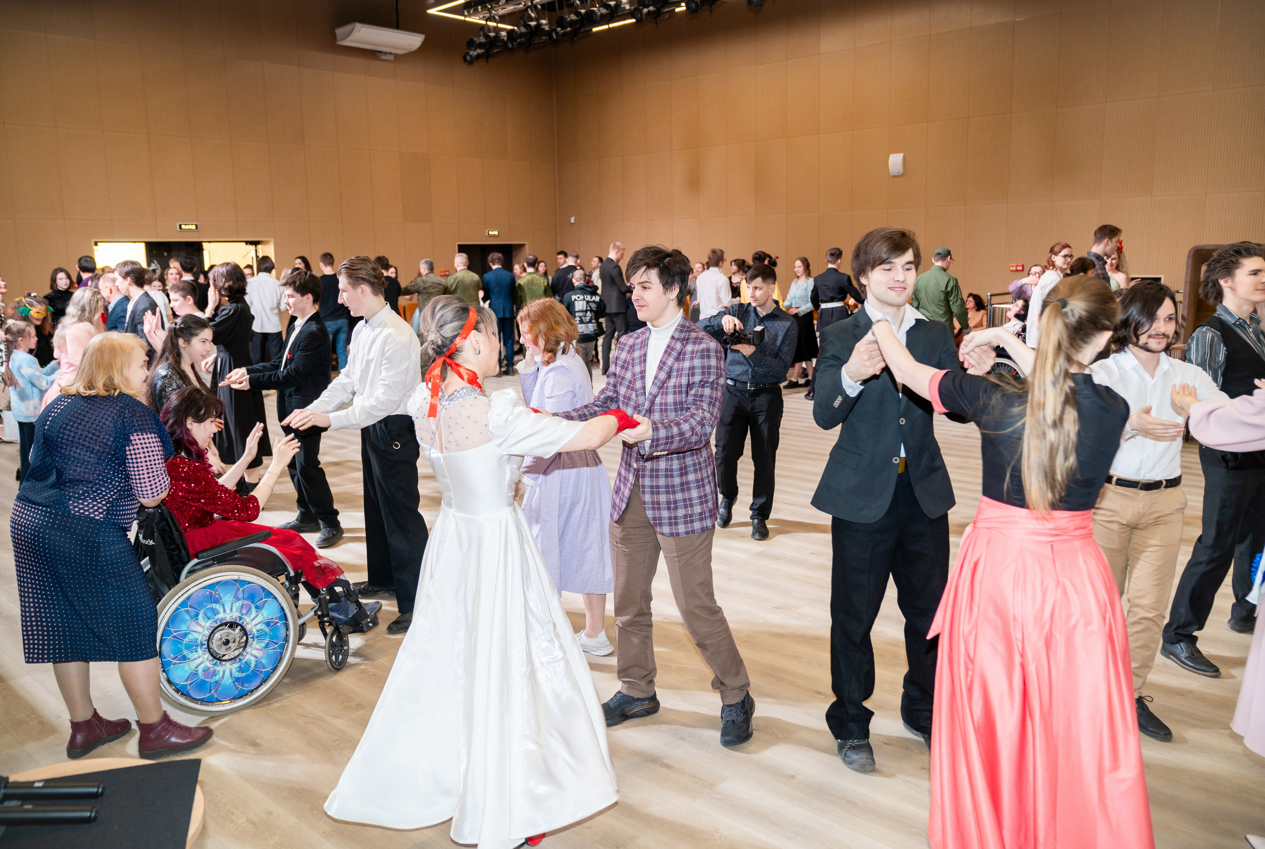 Общий план танцпола на инклюзивном балу «Мы все равны». Участники с инвалидностью и без танцуют вместе. Фотограф Мальцев Евгений.