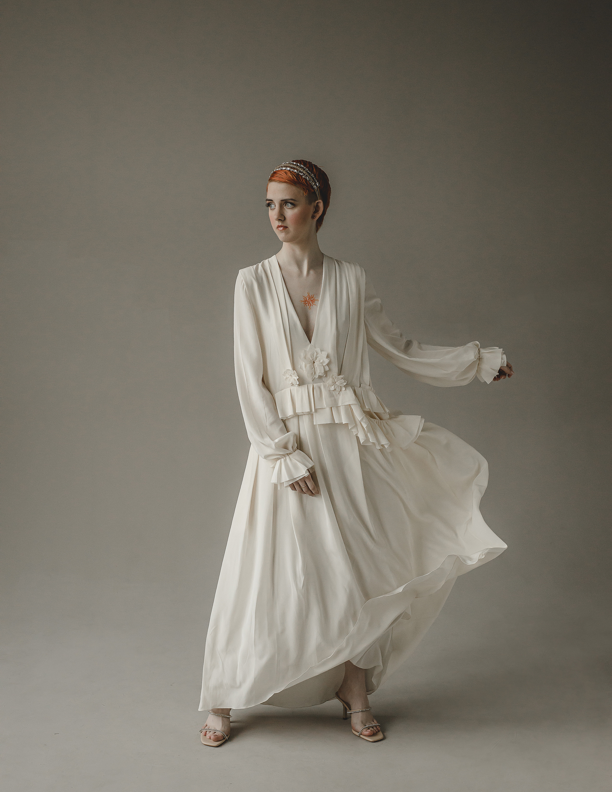 Рыжая девушка в летящем белом платье Виктории Бэкхем в студии 