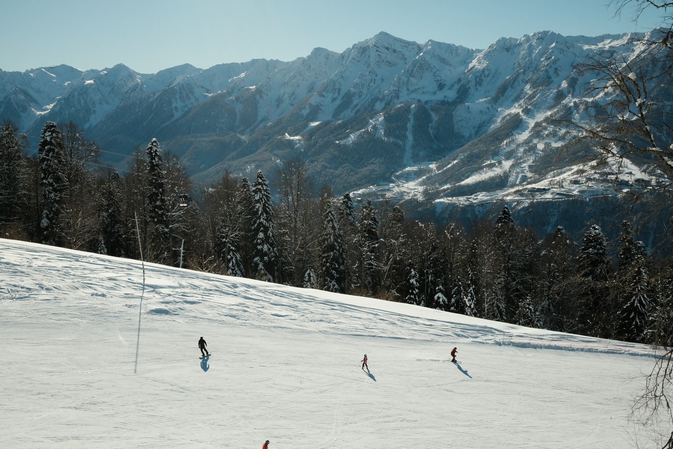 Горнолыжники едут на фоне Кавказских гор. Лаура
