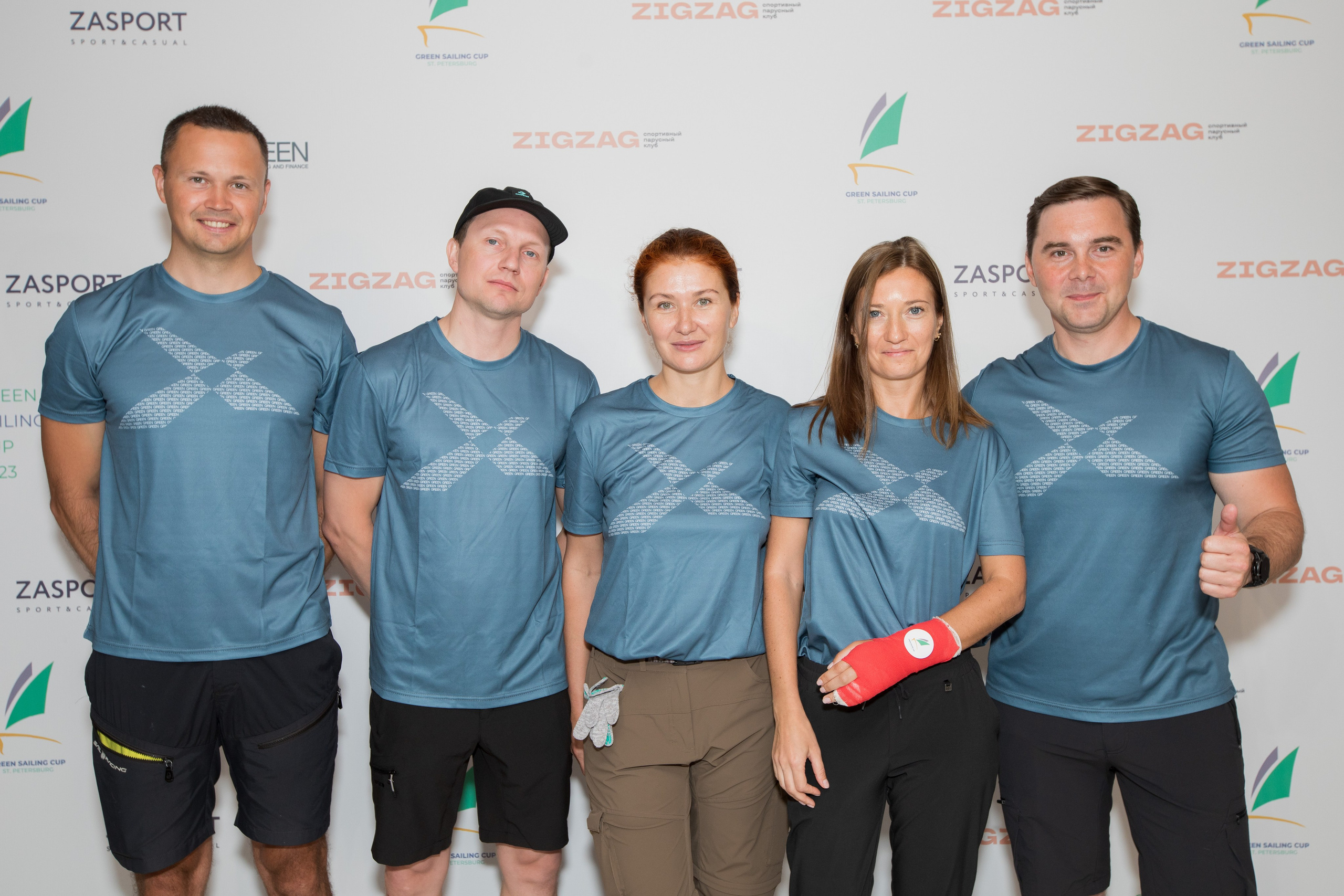 Команда яхтсменов фотографируется на фоне пресс-вола.