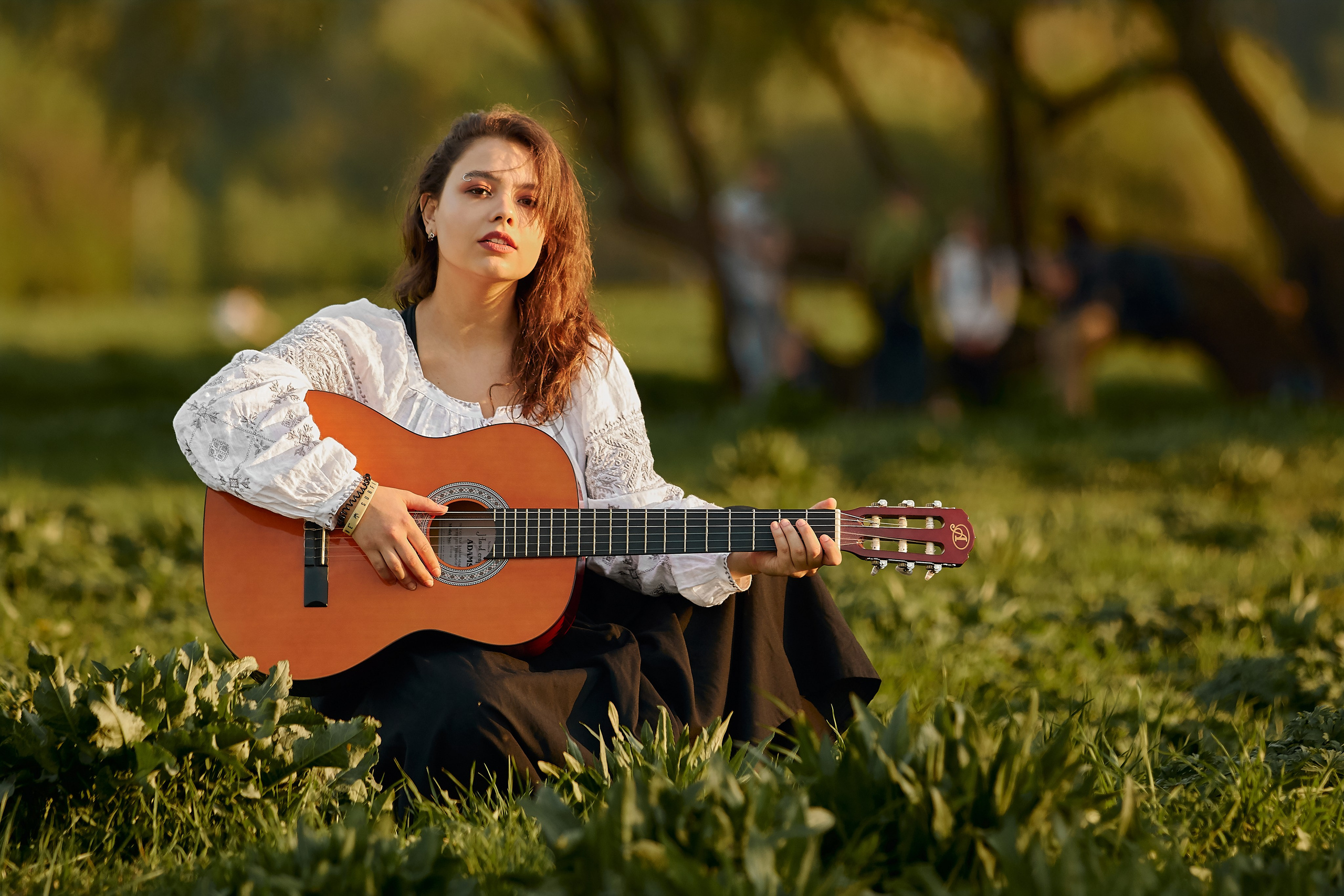 Alt-текст - Портрет девушки, сидящей на траве с гитарой в Царицынском парке, нежные весенние тона, фотограф Амил Курбанов