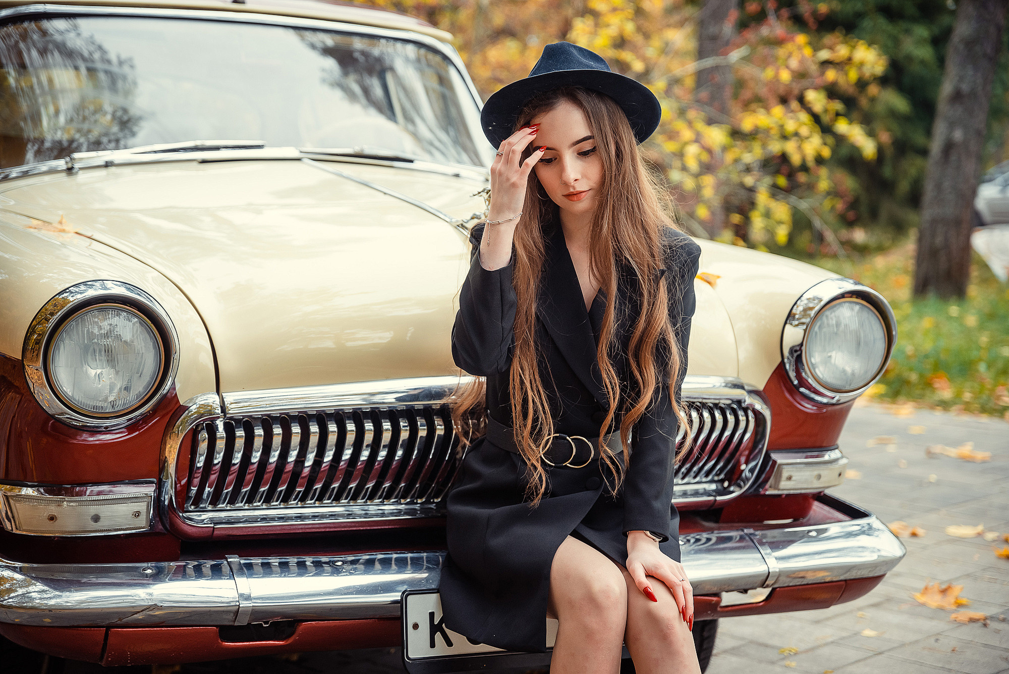 Ученица сидит у ретро авто