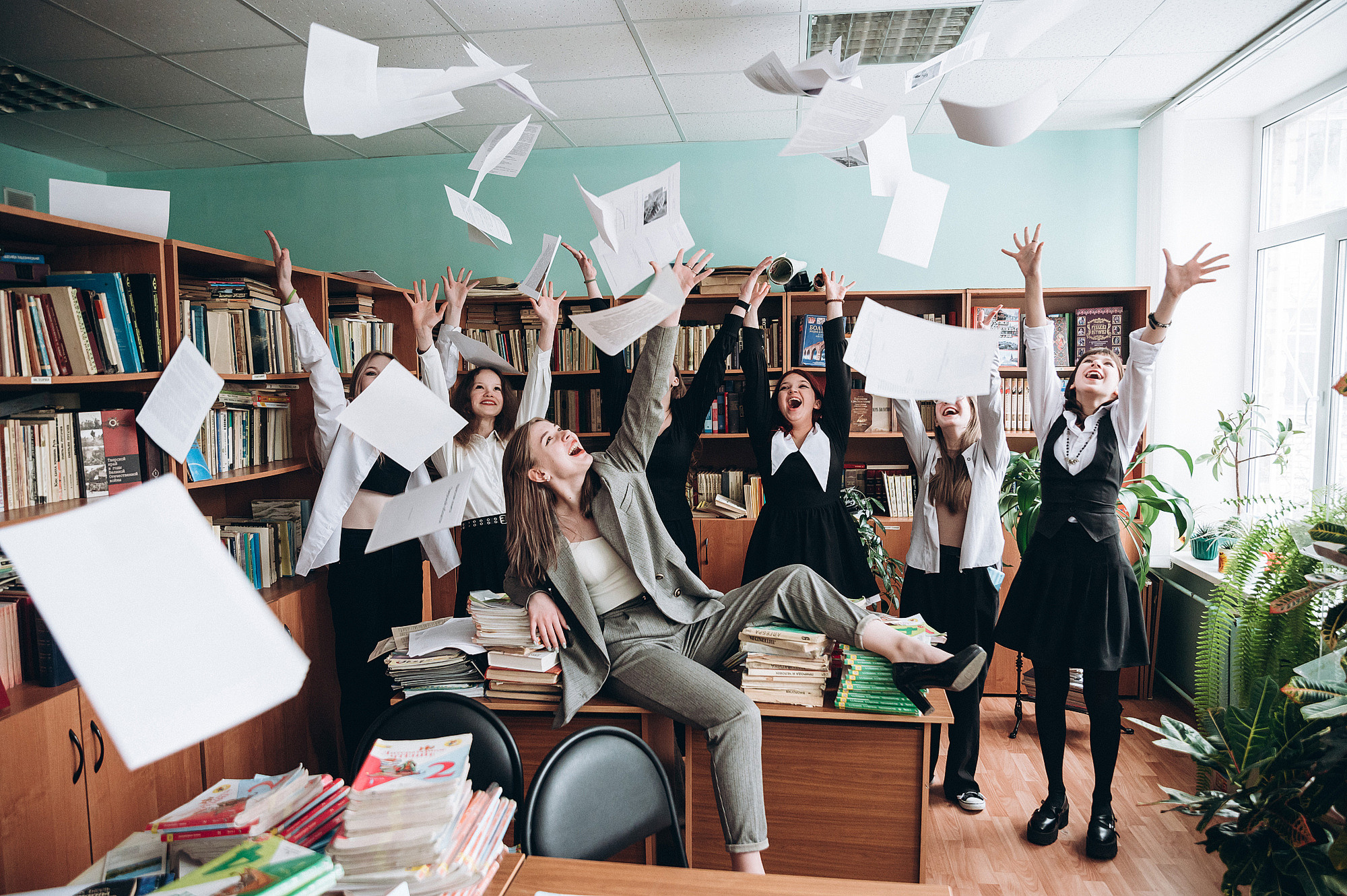 школьницы кидают листы бумаги