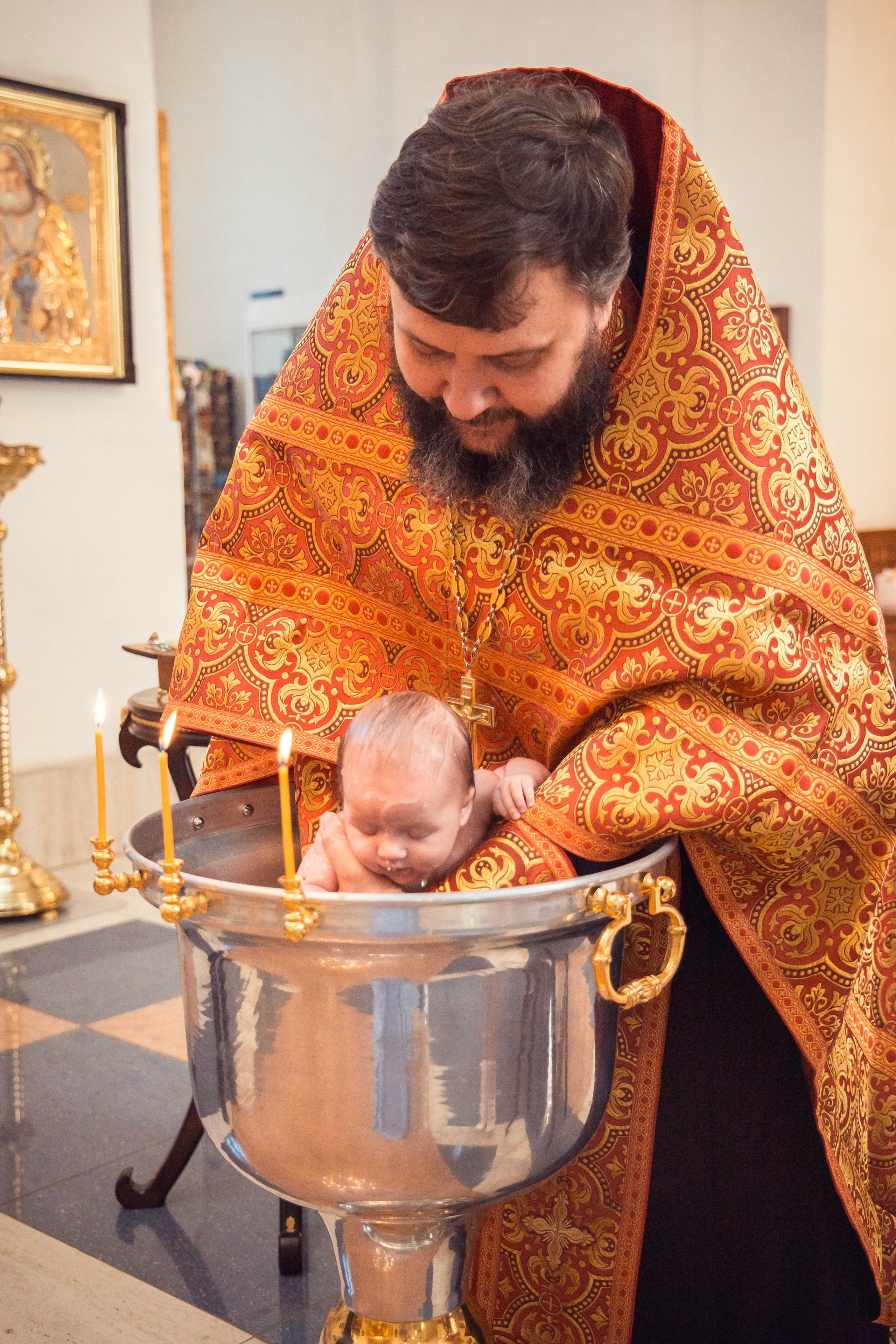 Окунание девочки во время таинства крещения. Фото Юлия Щедрина