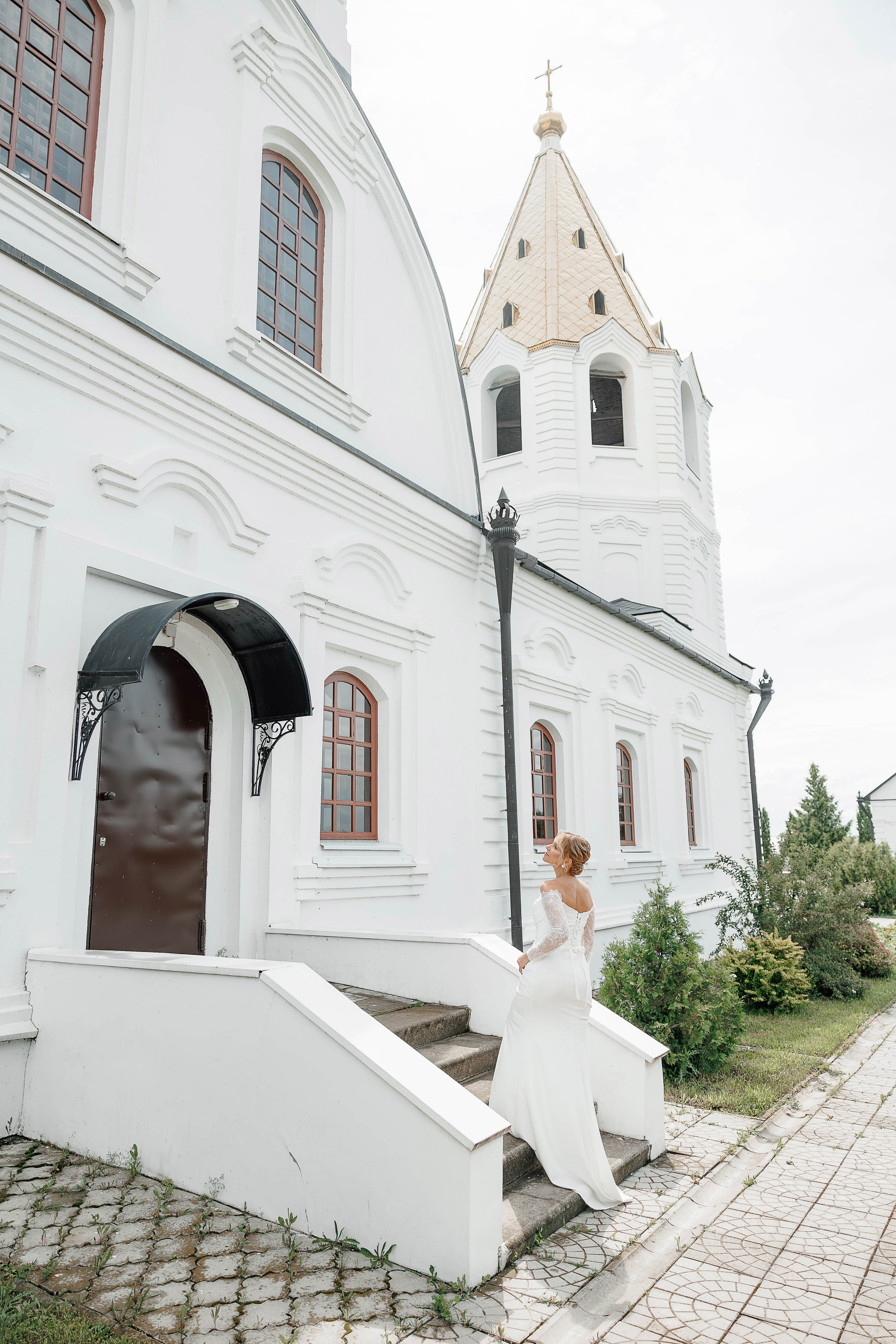 Жених держит за руку невесту на фоне церкви в Воронеже