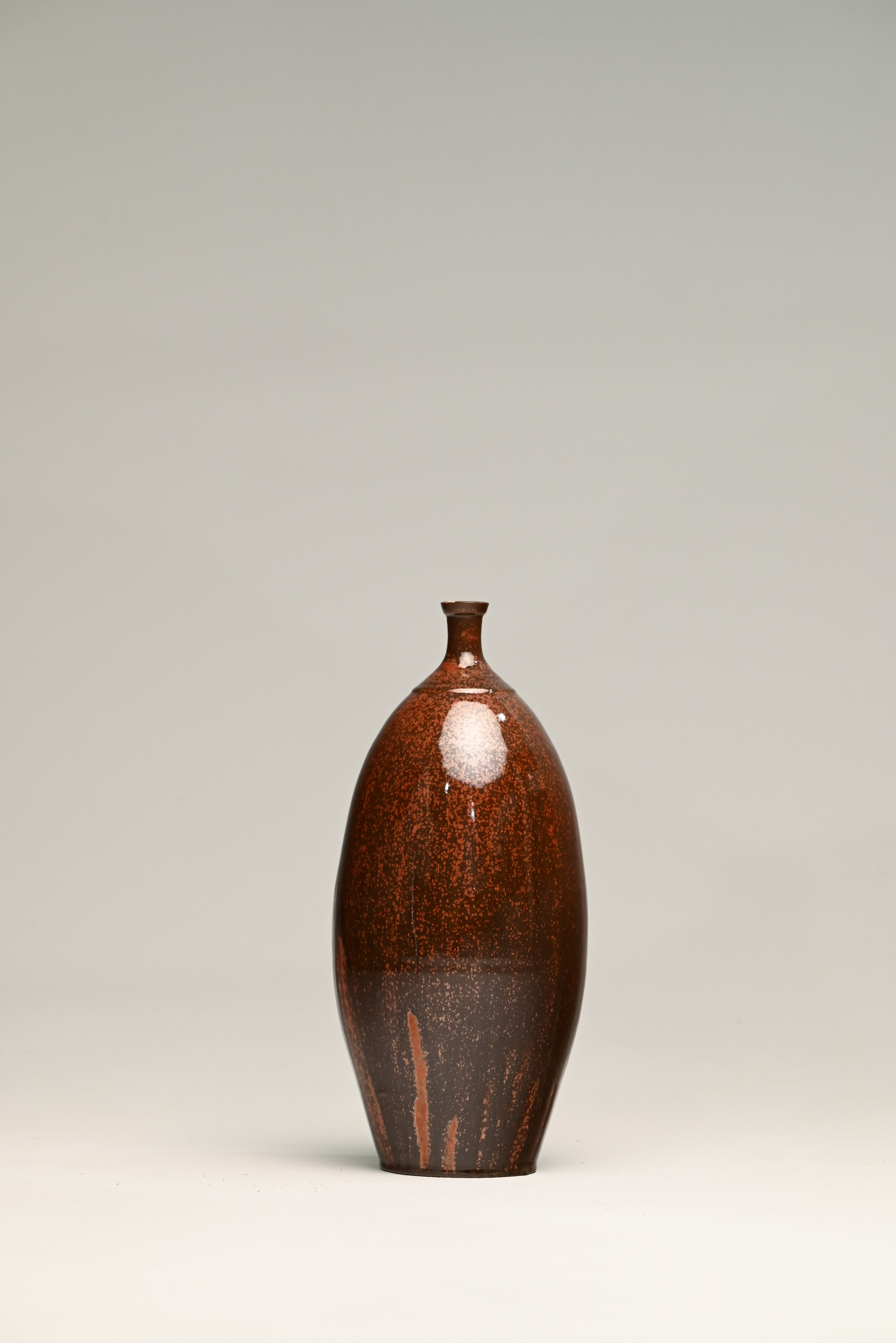 Каменная масса, глазурь. 44х19 см. Петрикор - землистый запах, который ощущается сразу после начала дождя. Коричневый цвет глазури напоминает землю, впервые напитанную влагой после засухи. Поверхность гладкая и обтекаемая, как если бы вещество само стремилось принять форму движения воды. В этом сосуде соединяются запах дождя, влажная теплая почва и мгновение, когда сухая материя вновь становится живой.