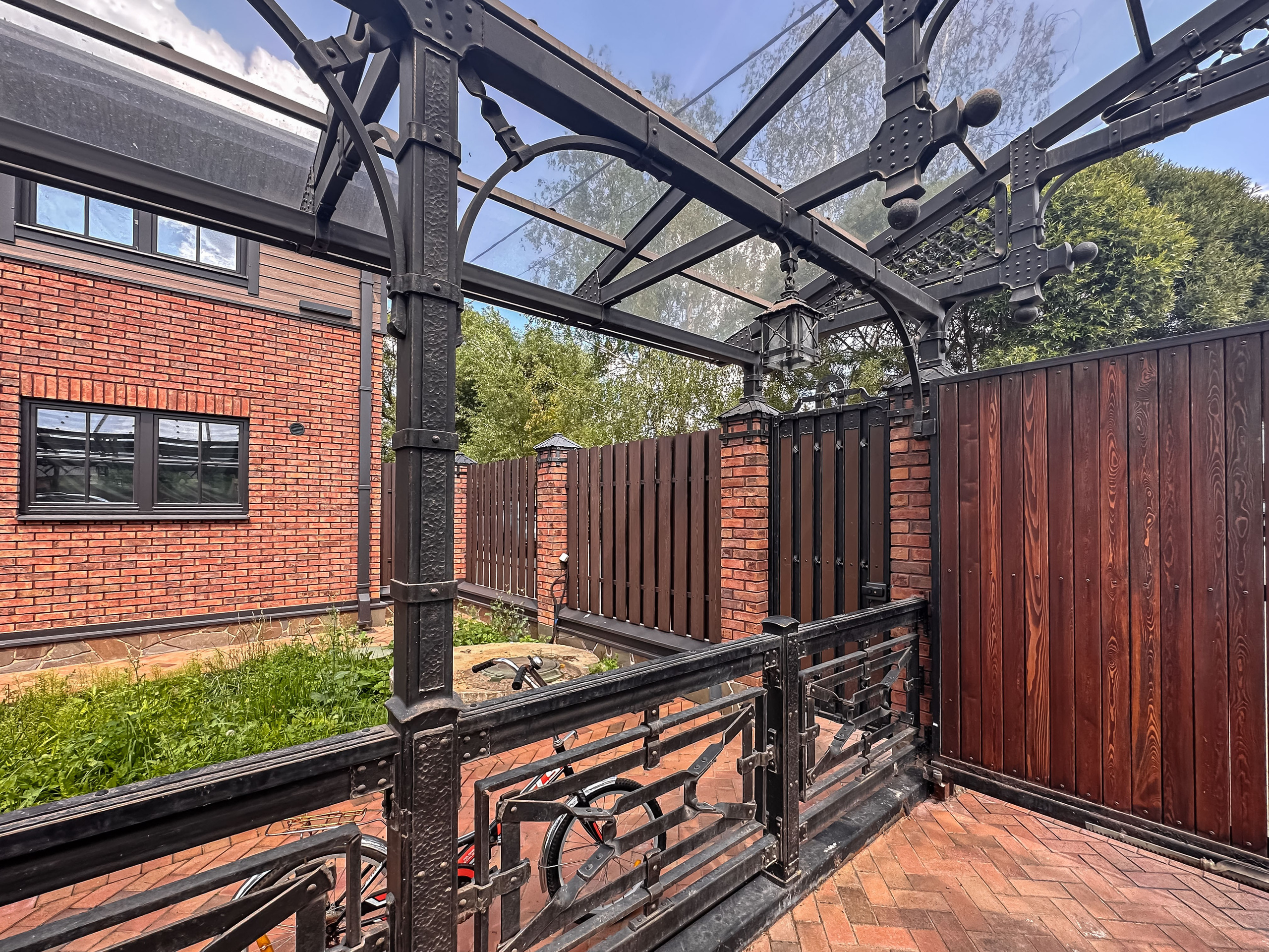 Общий вид комплекса — гараж, забор, ворота и мощёная площадка. Единый архитектурный ансамбль в стиле Лофт