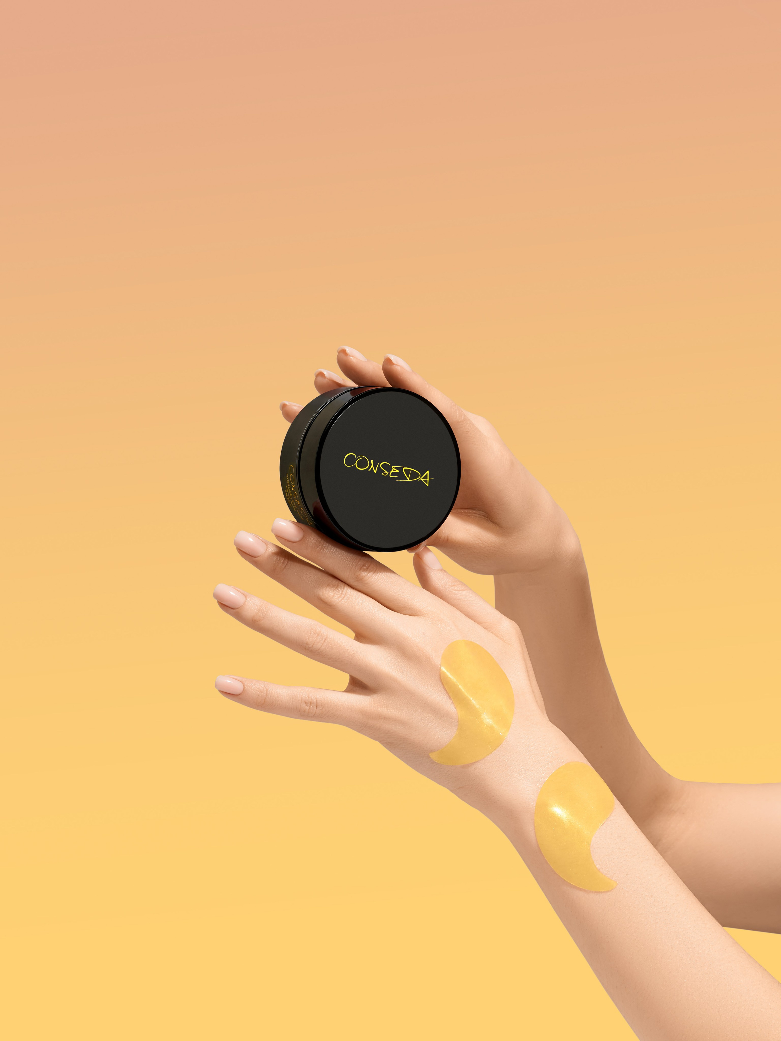 Руки девушки держат черную круглую коробочку на желтом фоне