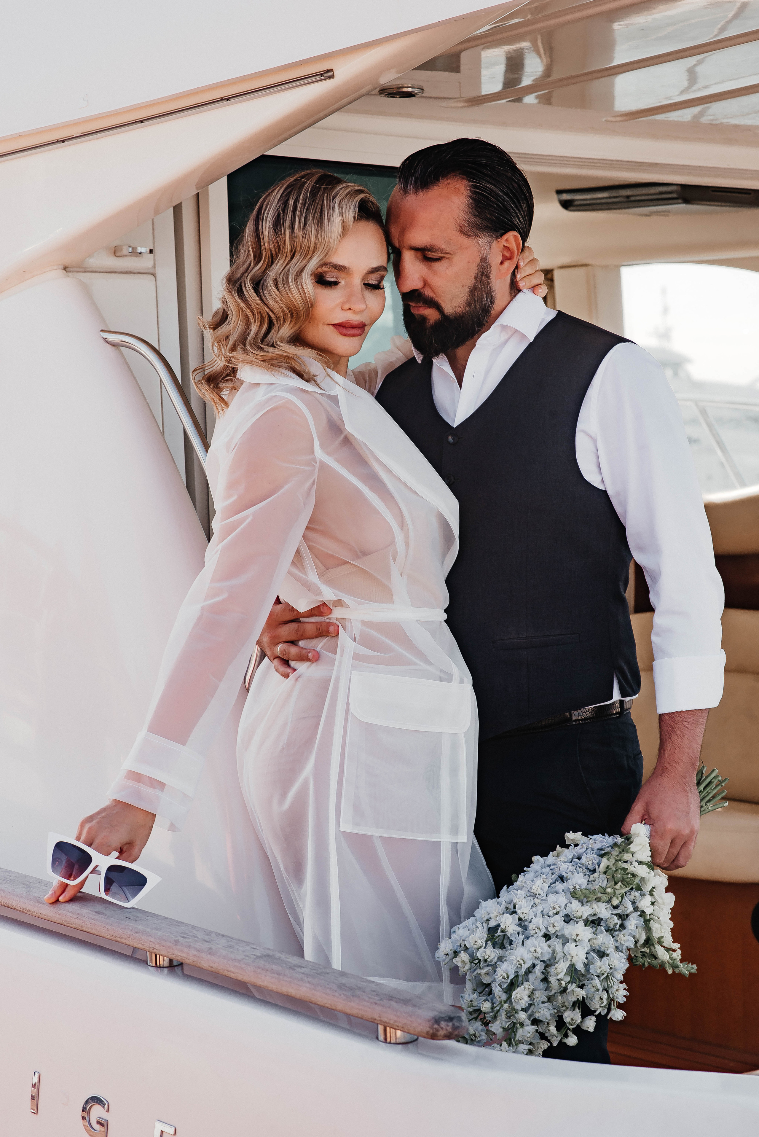 жених обнимает невесту на яхте