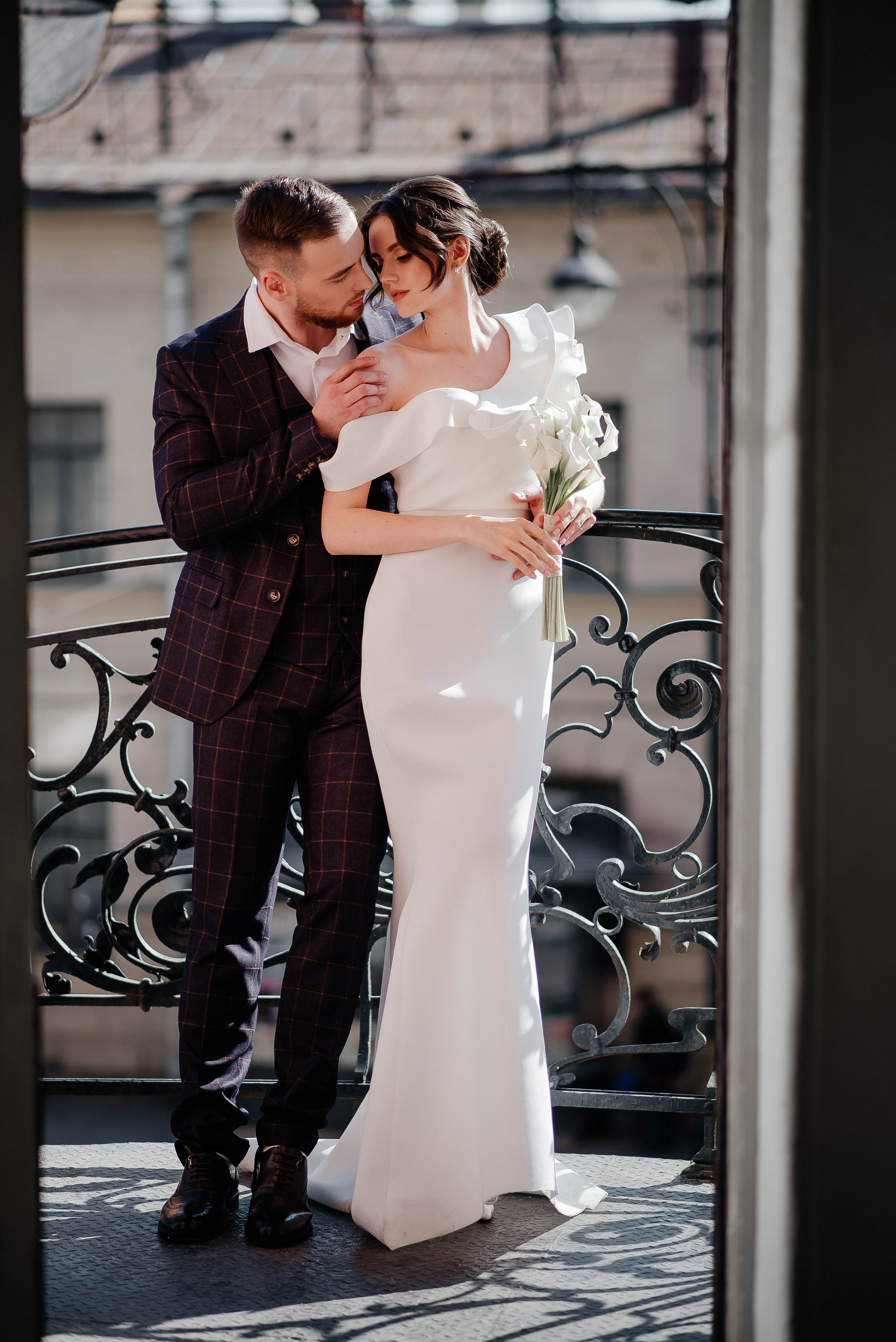 жених целует невесту на балконе