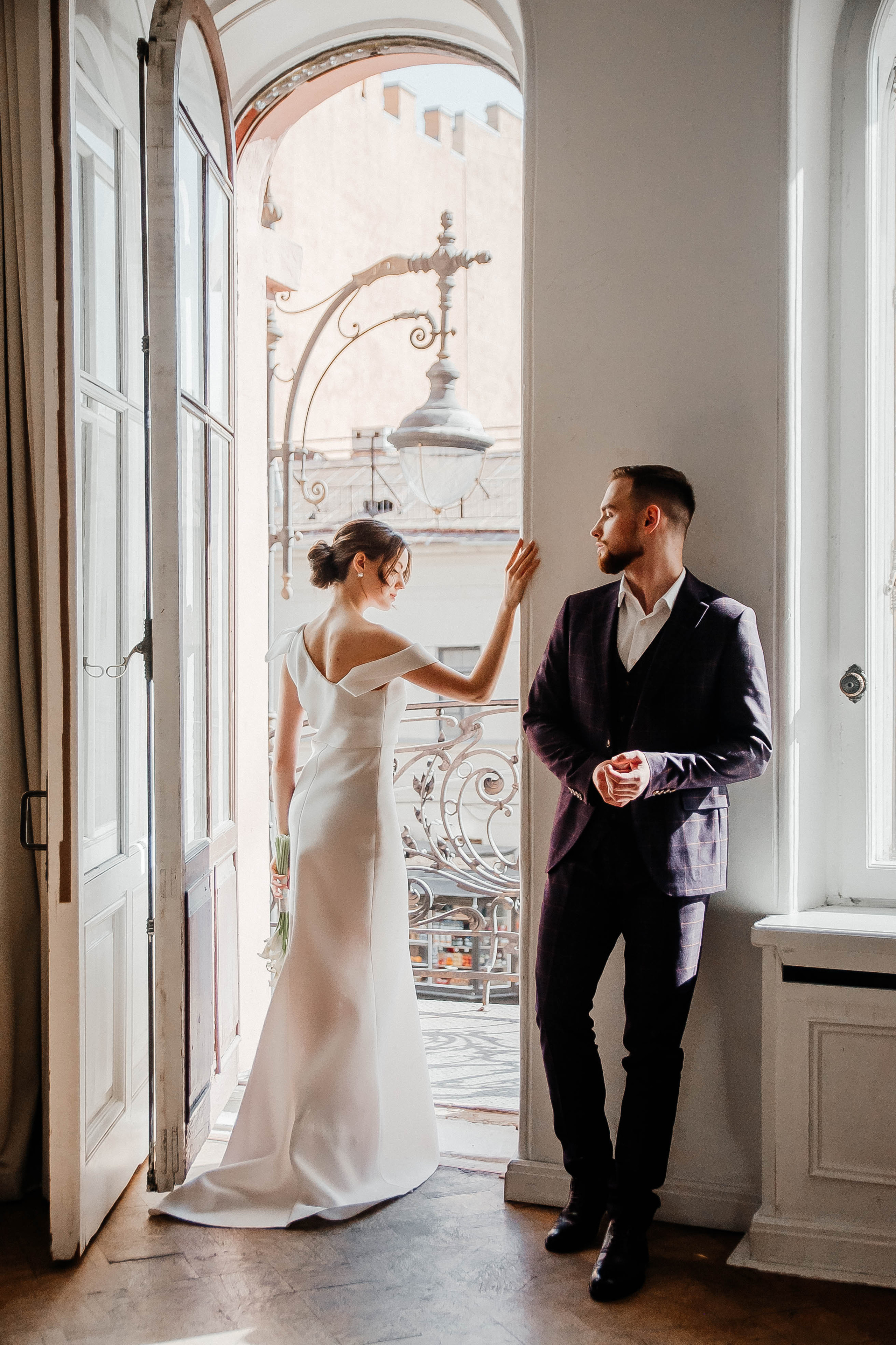 невеста фотографируется на фоне балкона