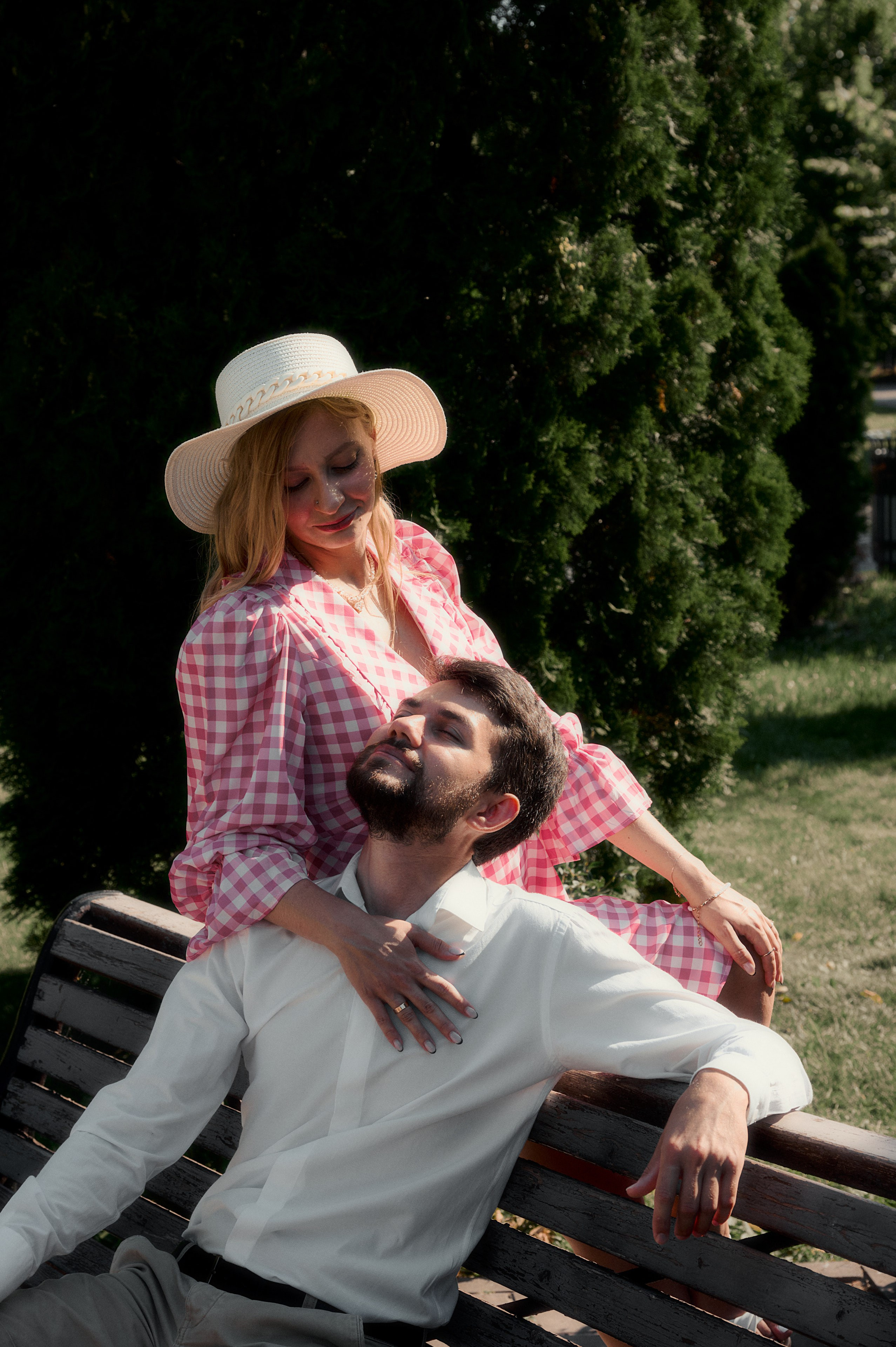 Елизавета в шляпе сидит на лавке рядом с Юрием, оба смеются.