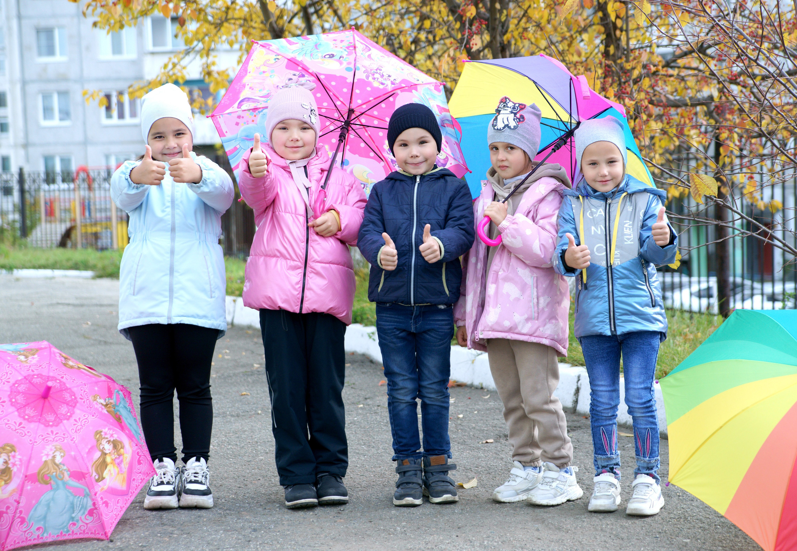 Осенняя фотосессия выпускников детского сада - друзья показывают класс с зонтами