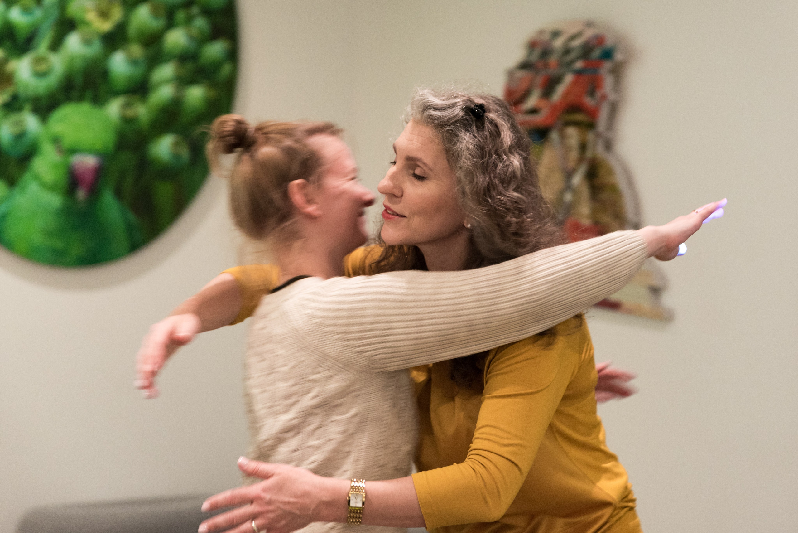 Женщина психолог ведущая семинара обнимает слушательницу.