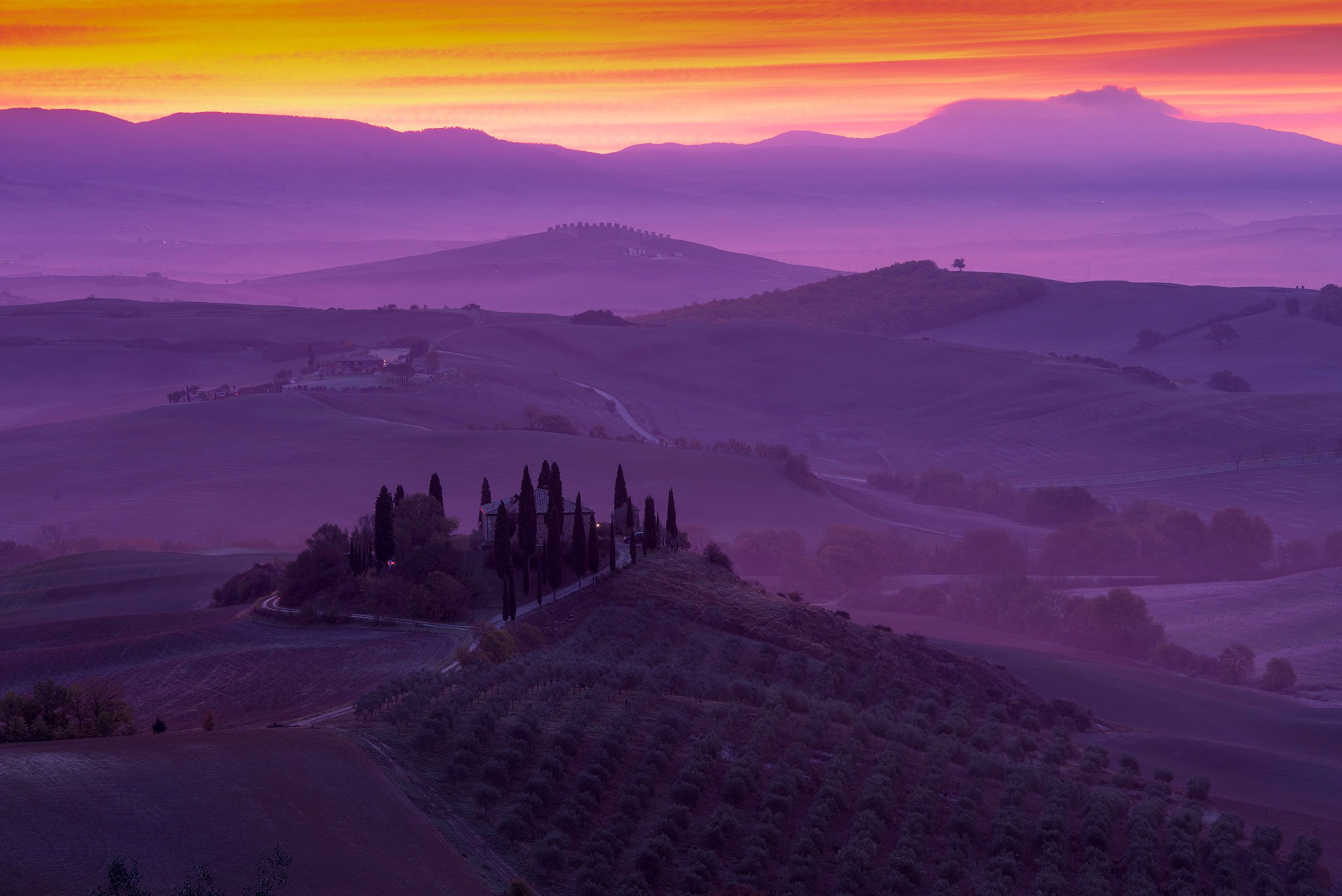 Художественный пейзаж Тосканы на рассвете: волнистые холмы, окутанные фиолетовой дымкой, с акцентом на группу кипарисов и фермерский дом на вершине холма, драматичные цвета неба.