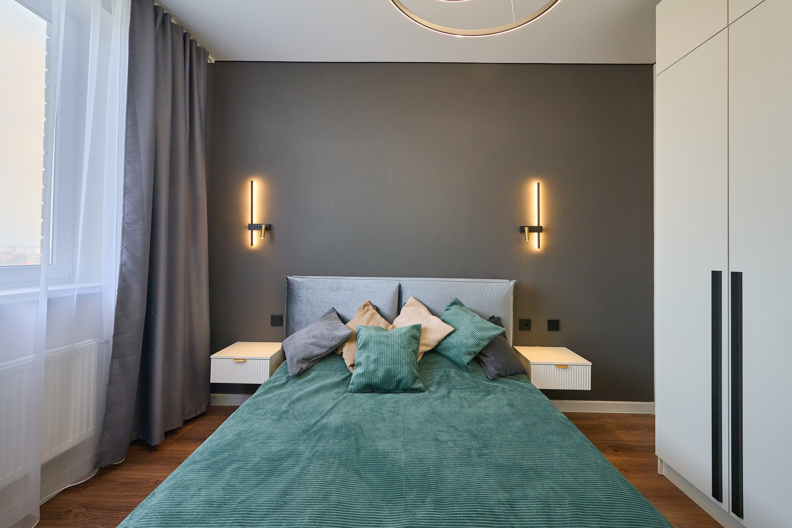 комната серые обои серые шторы бирюзовый диван и покрывало 