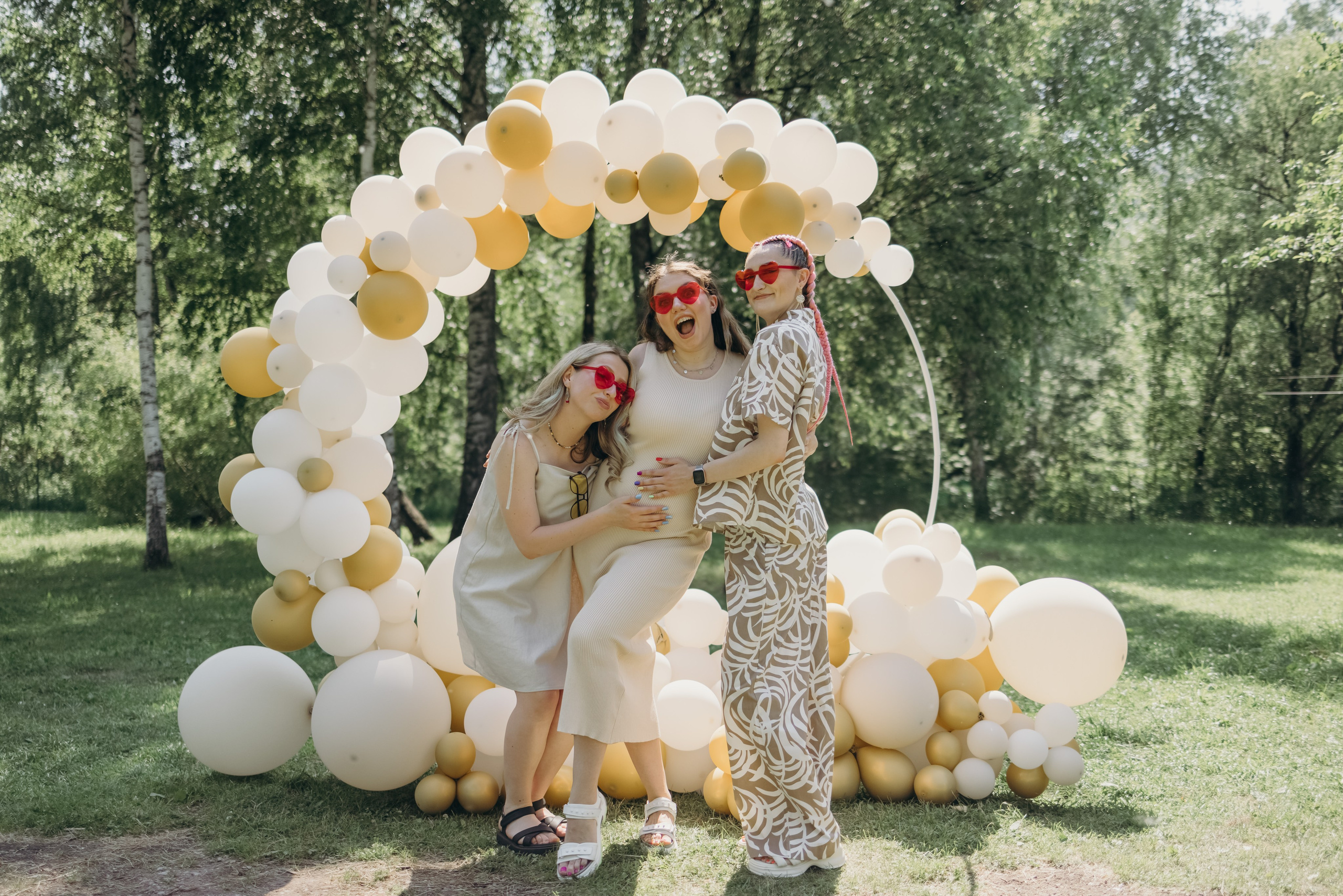 Беременная девушка обнимается с подругами