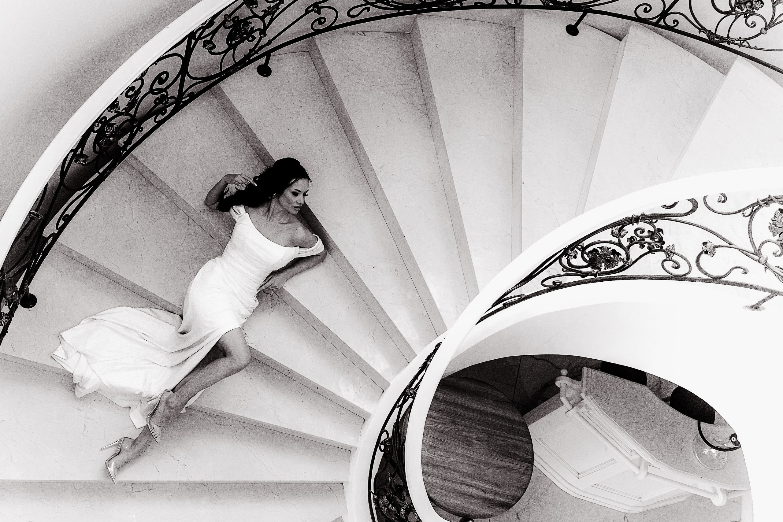 Невеста в платье лежит на красивой винтажной лестнице