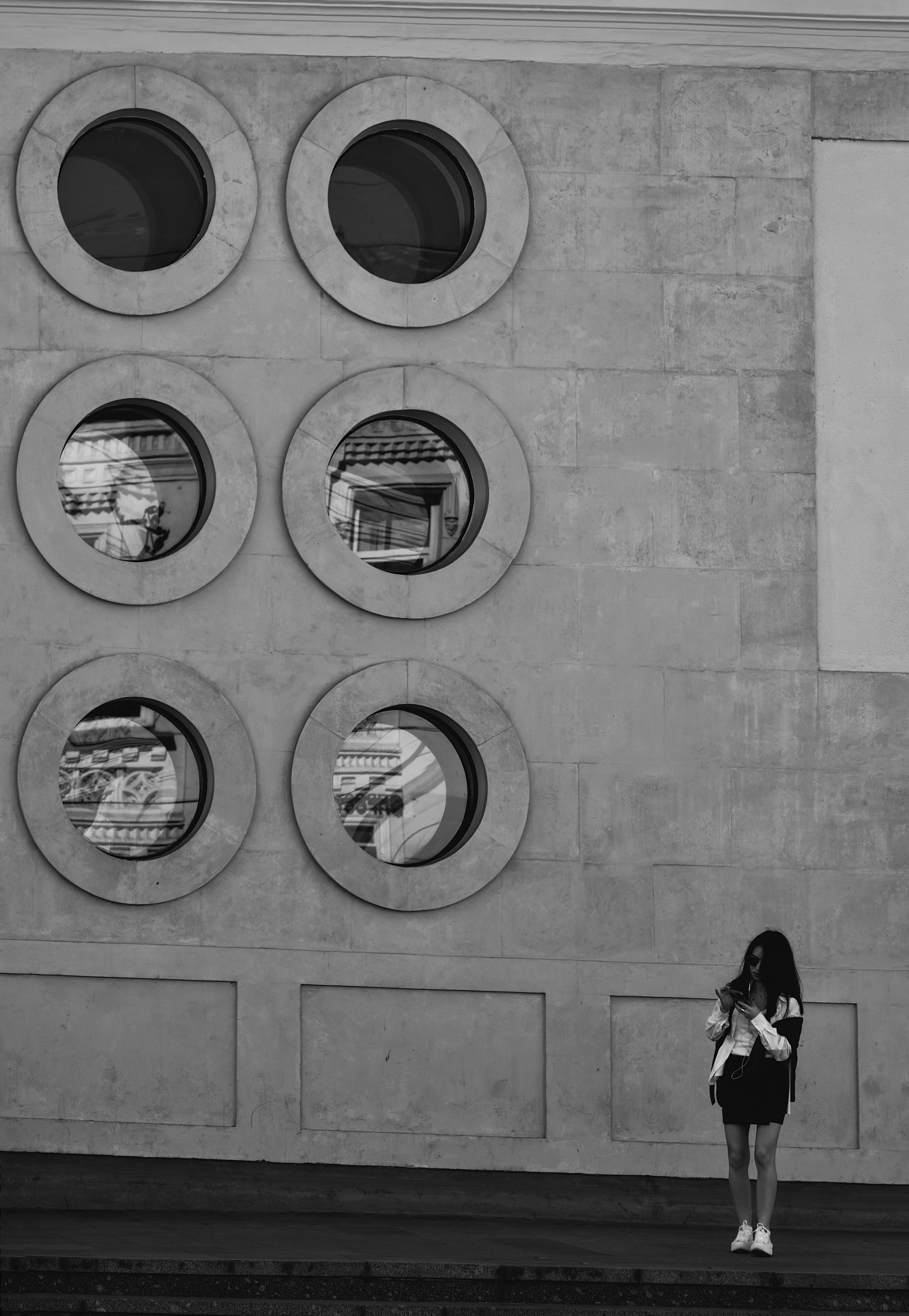 Девушка рядом с круглыми окнами павильона станции Чистые Пруды