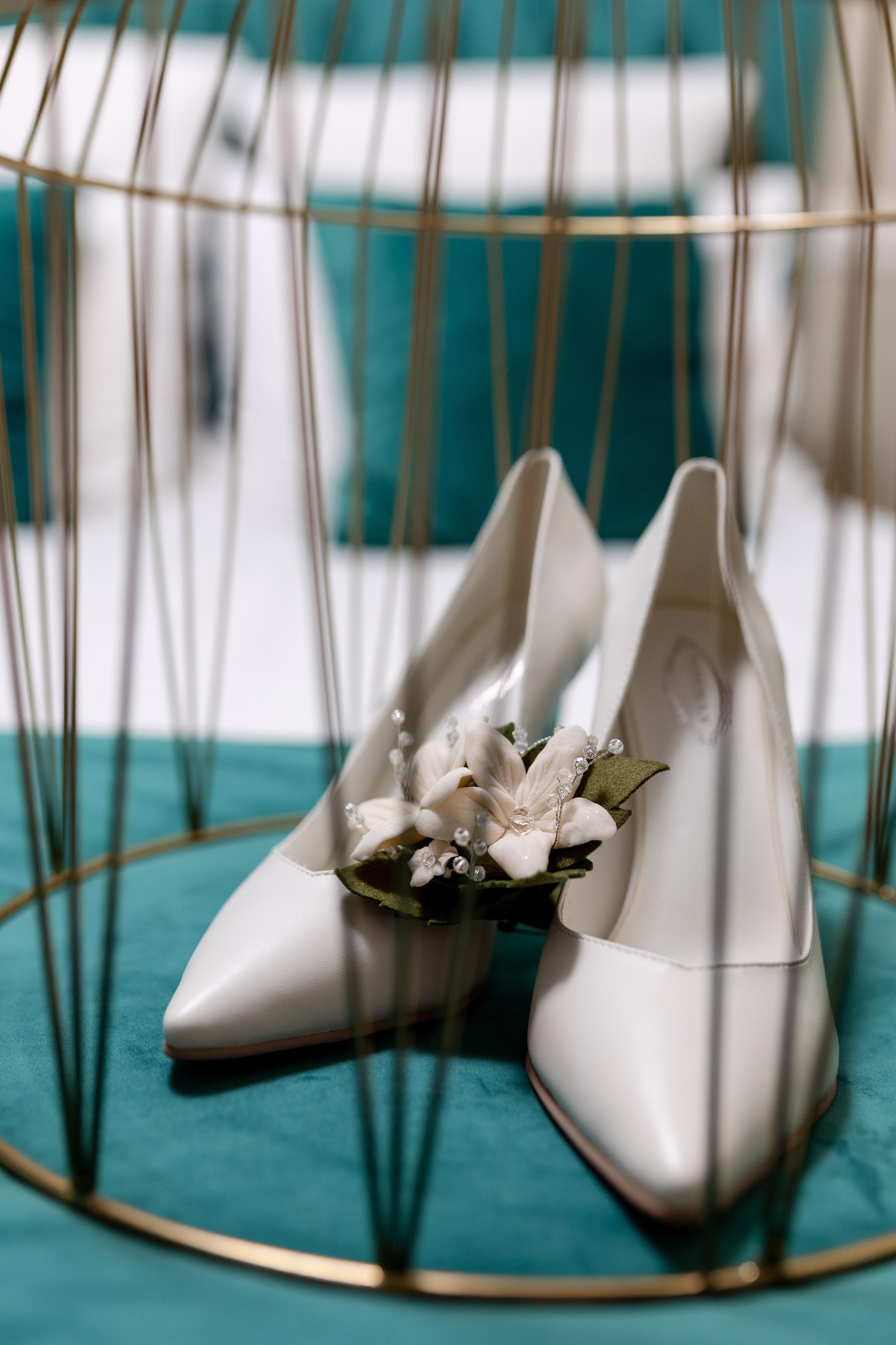 Туфельки невесты украшены цветами и накрыты золотой клеткой.