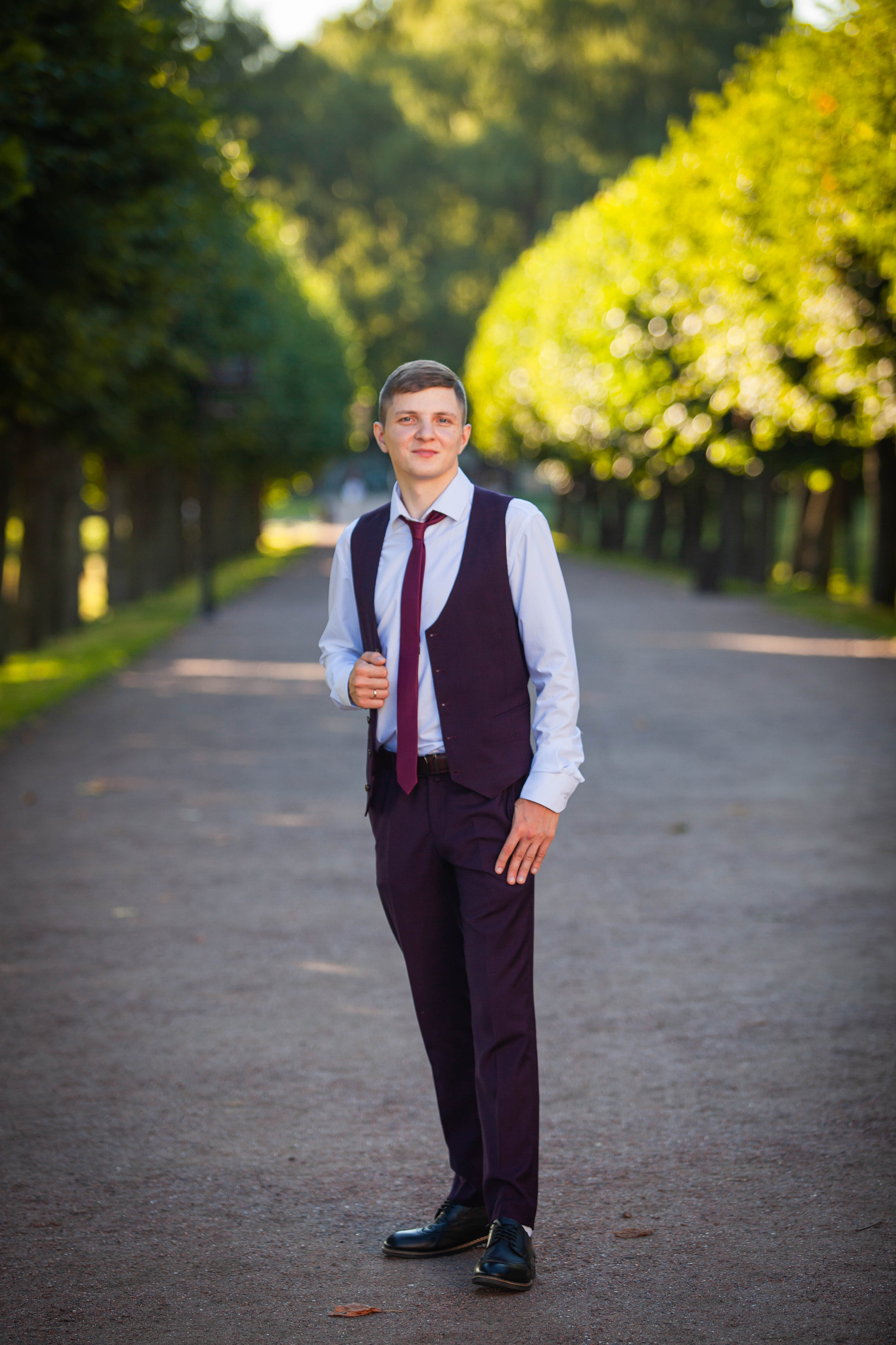 Жених позирует на аллее в Кусково во время фотосессии