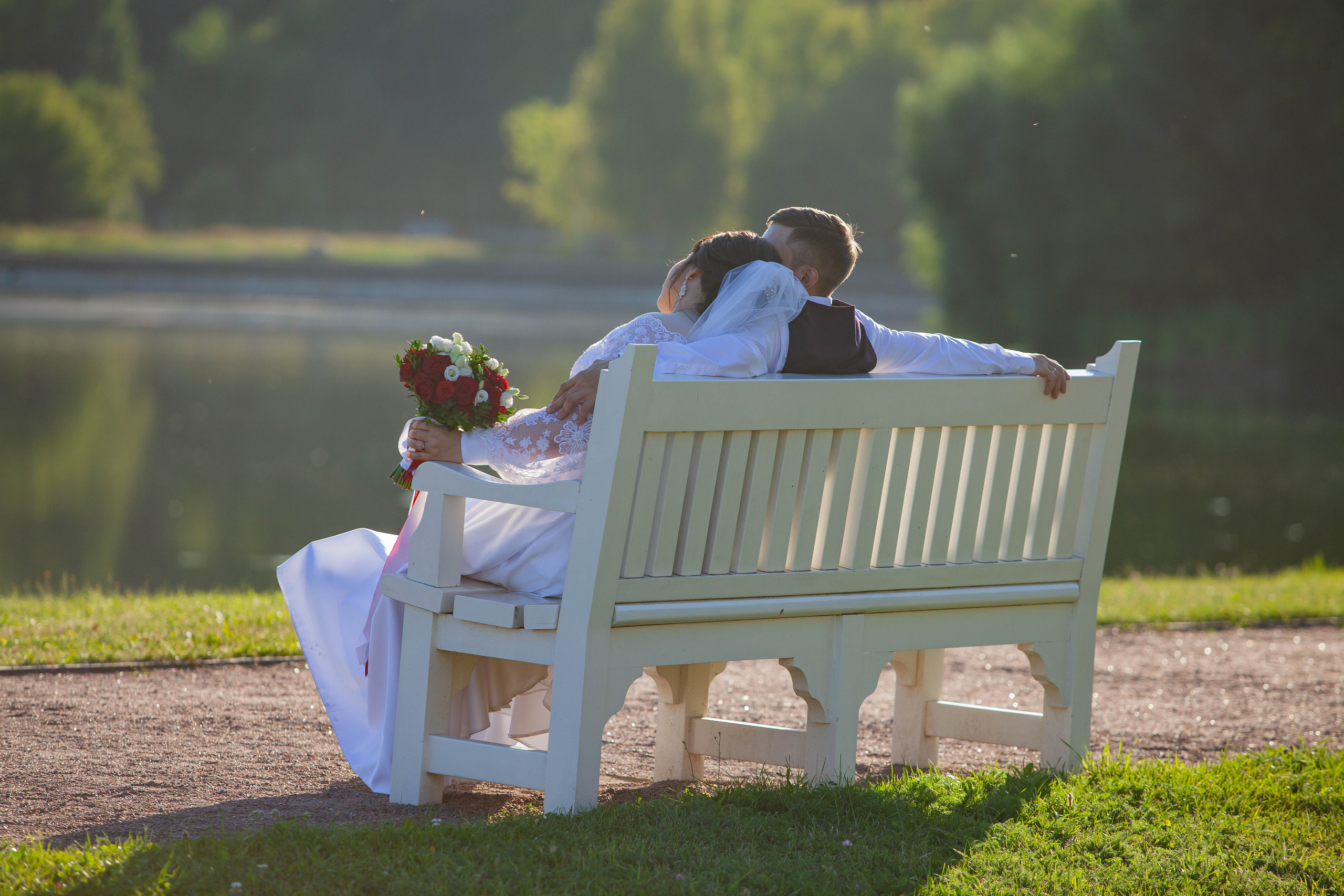 Молодожены на белой лавочки во время фотосессии в Кусково