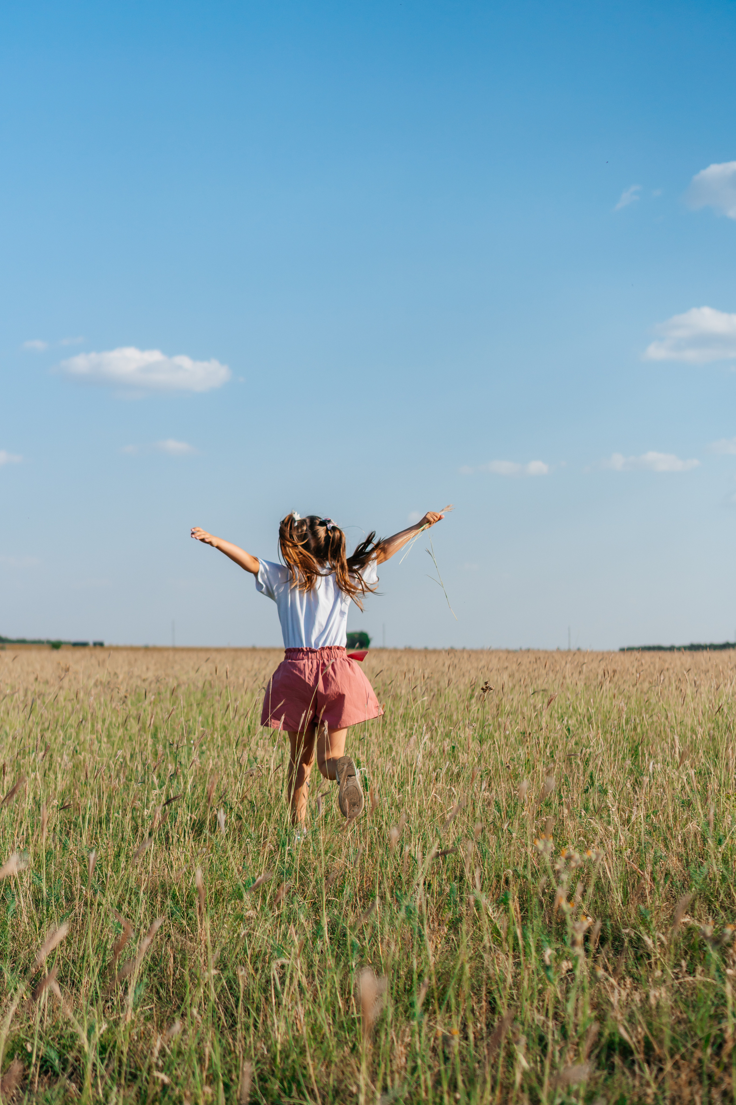 маленькая девочка бежит в поле
