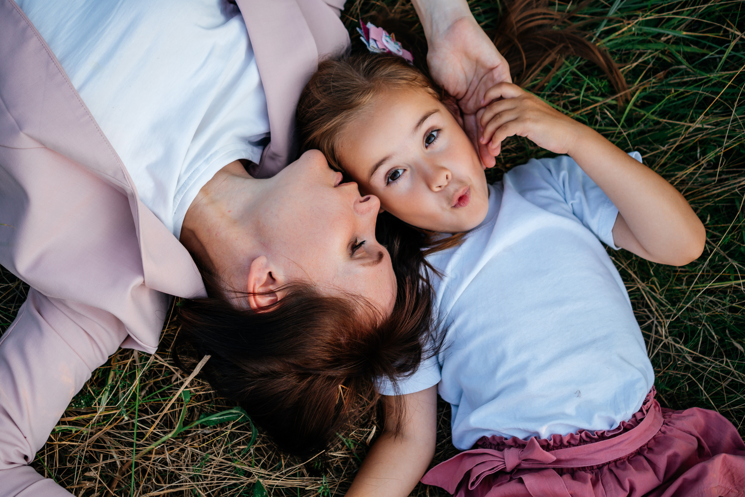 мама и дочь лежат на траве 