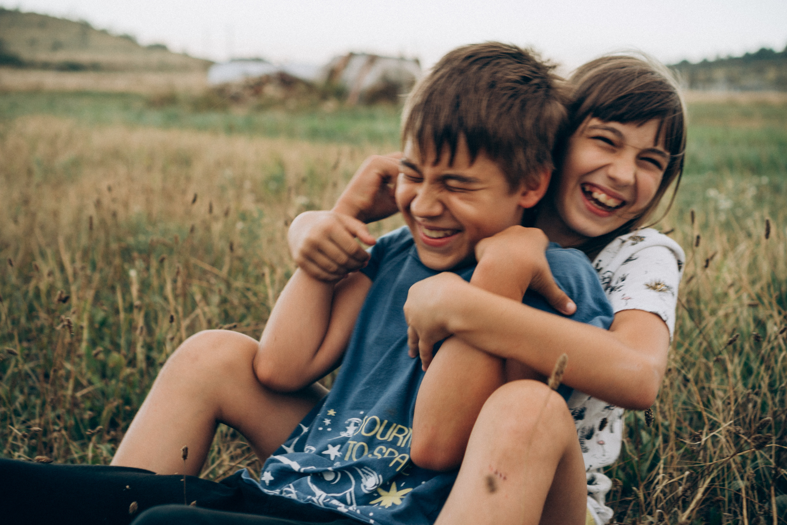 мальчик и девочка играют в поле