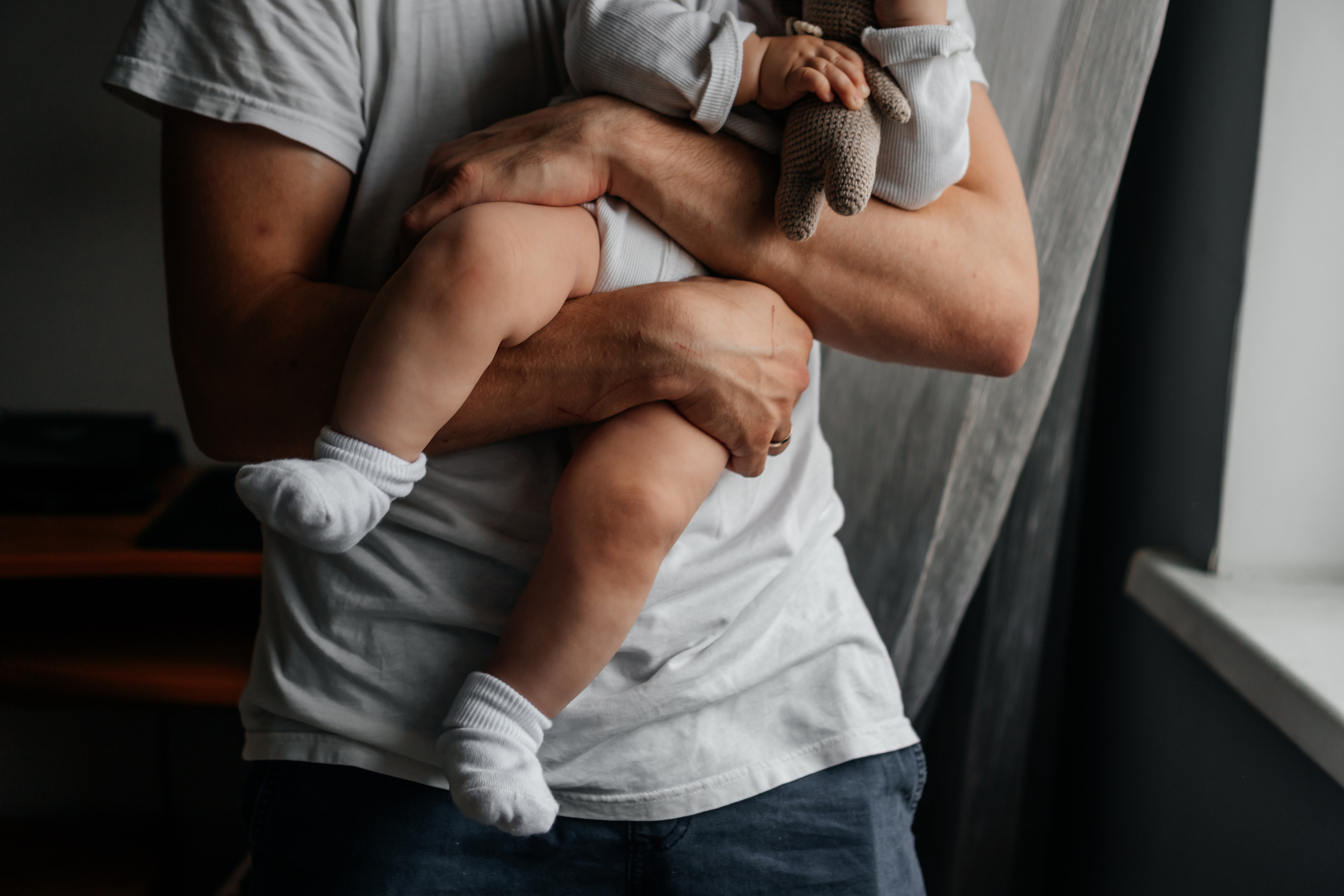 папа держит на руках своего маленького ребенка