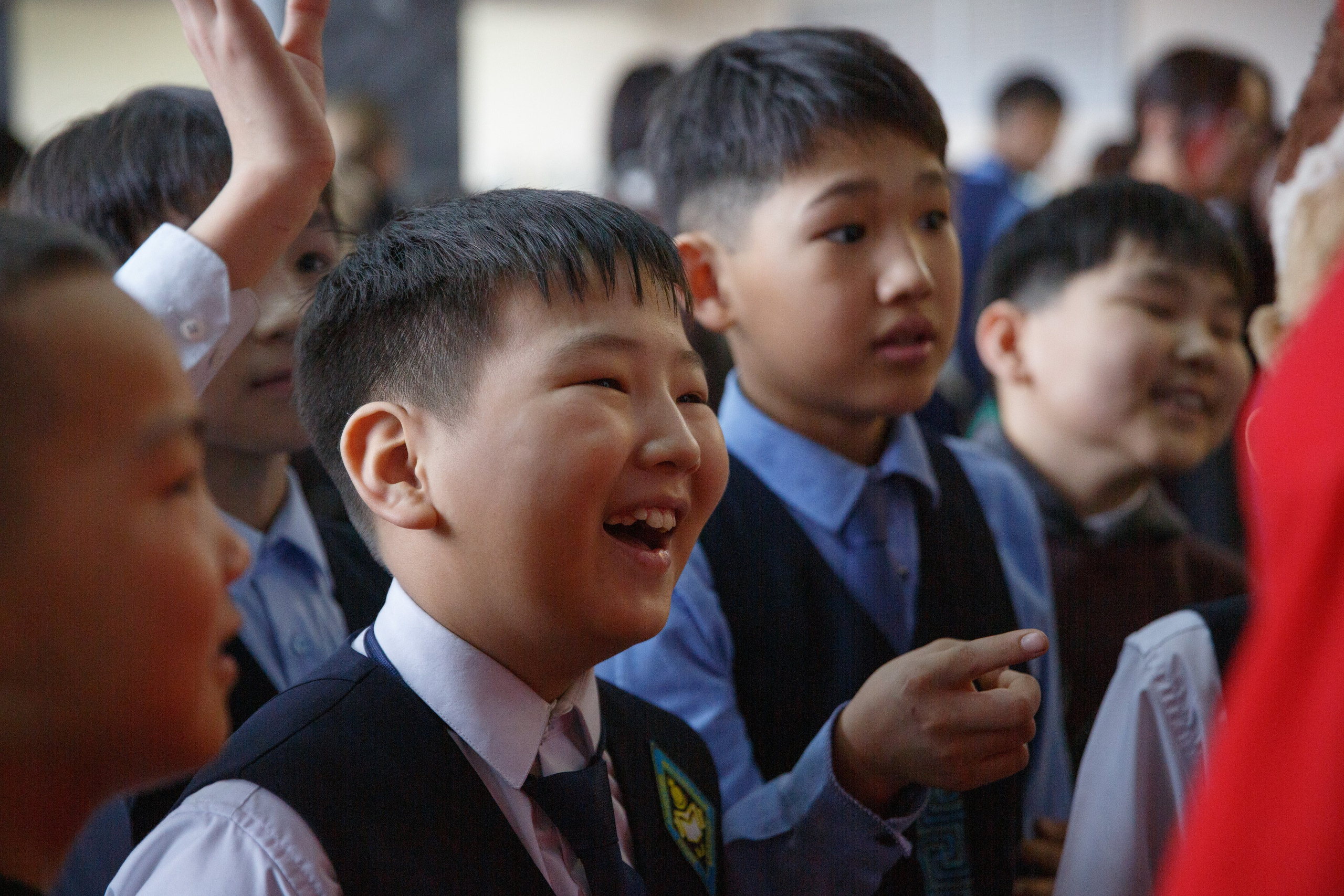 Школьники смеются и общаются в зале.