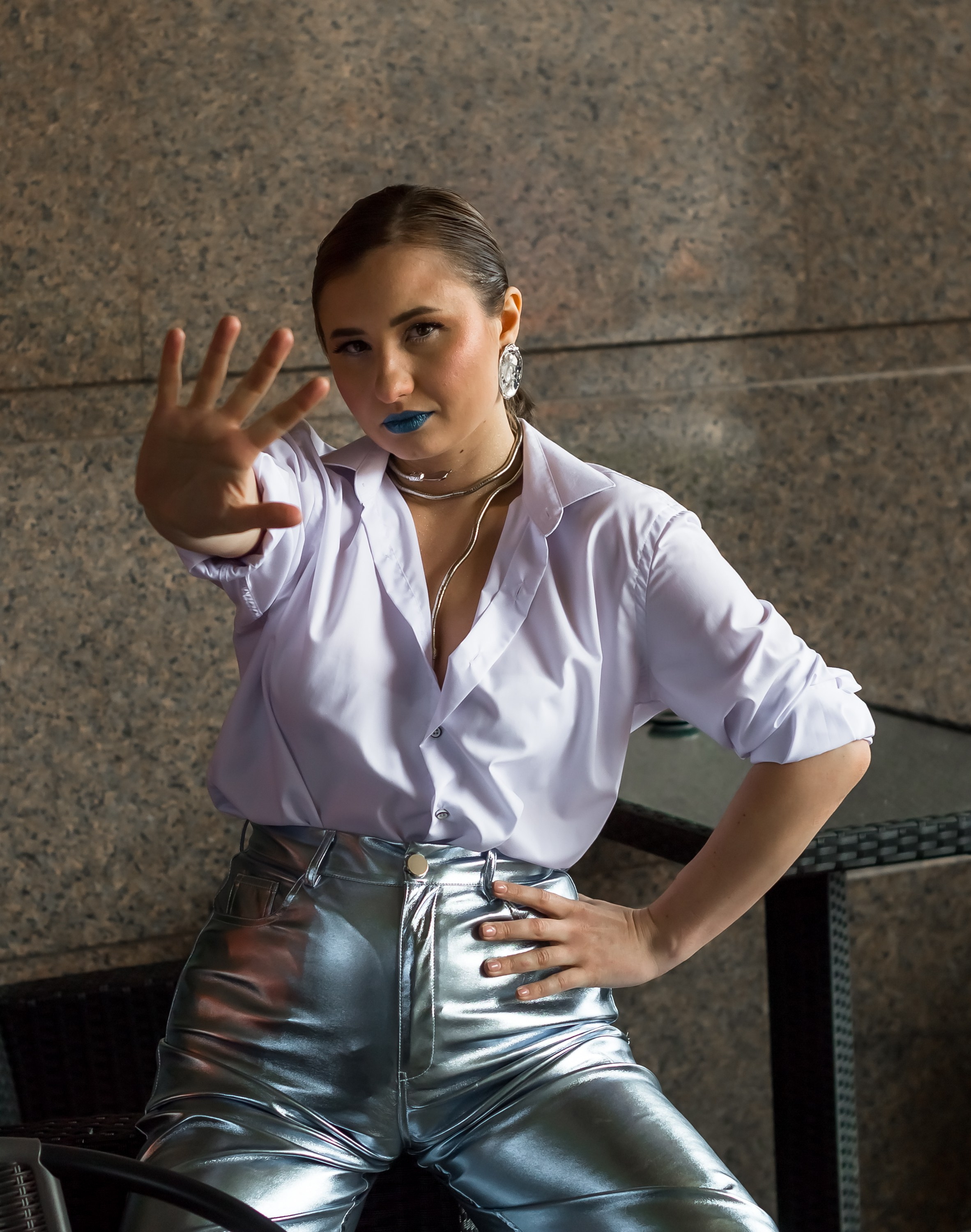 На фото девушка в белой рубашке протянула вперед руку.