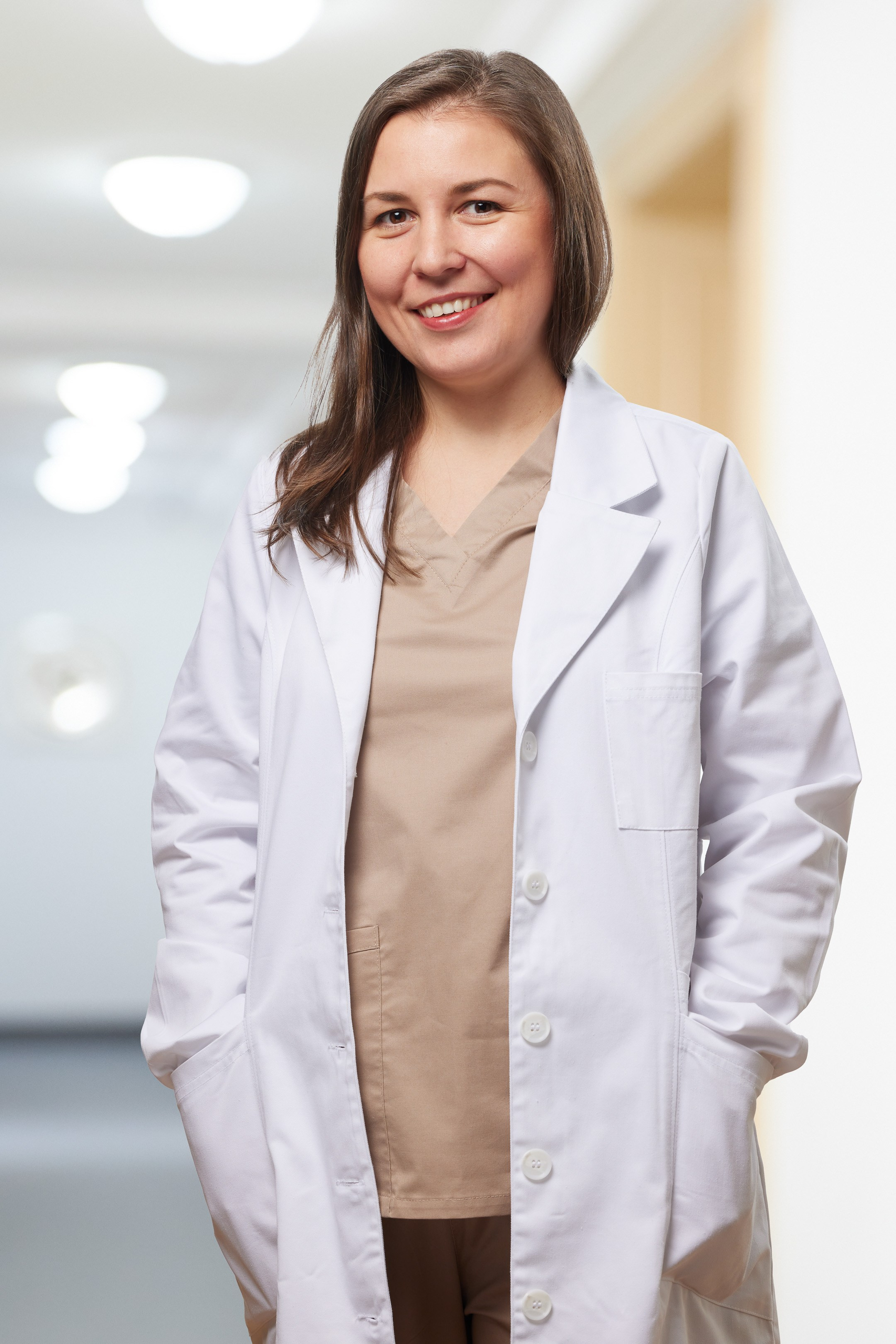 Business portrait of a young female doctor against a blurred interior background - photographer Andrey Dunin